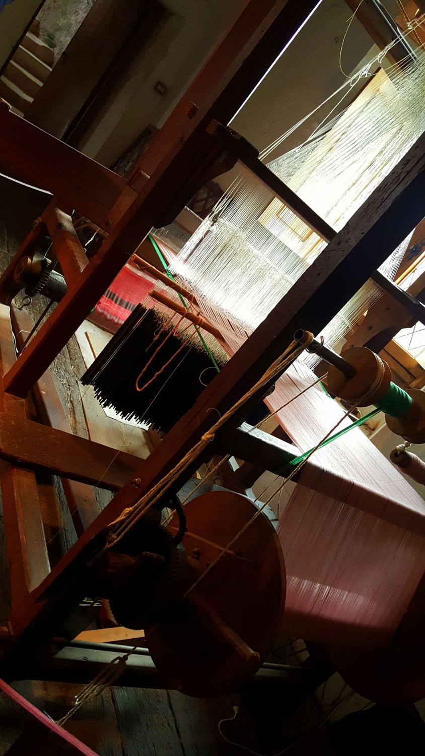 Gros plan sur un métier à tisser en action au musée de Varaignes, artisanat traditionnel du Périgord Vert