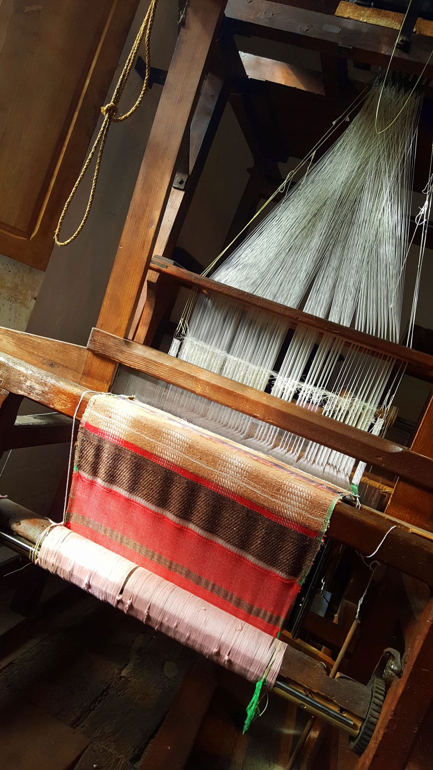 Tissu traditionnel rayé en cours de tissage sur un métier à tisser ancien au musée de Varaignes, Dordogne