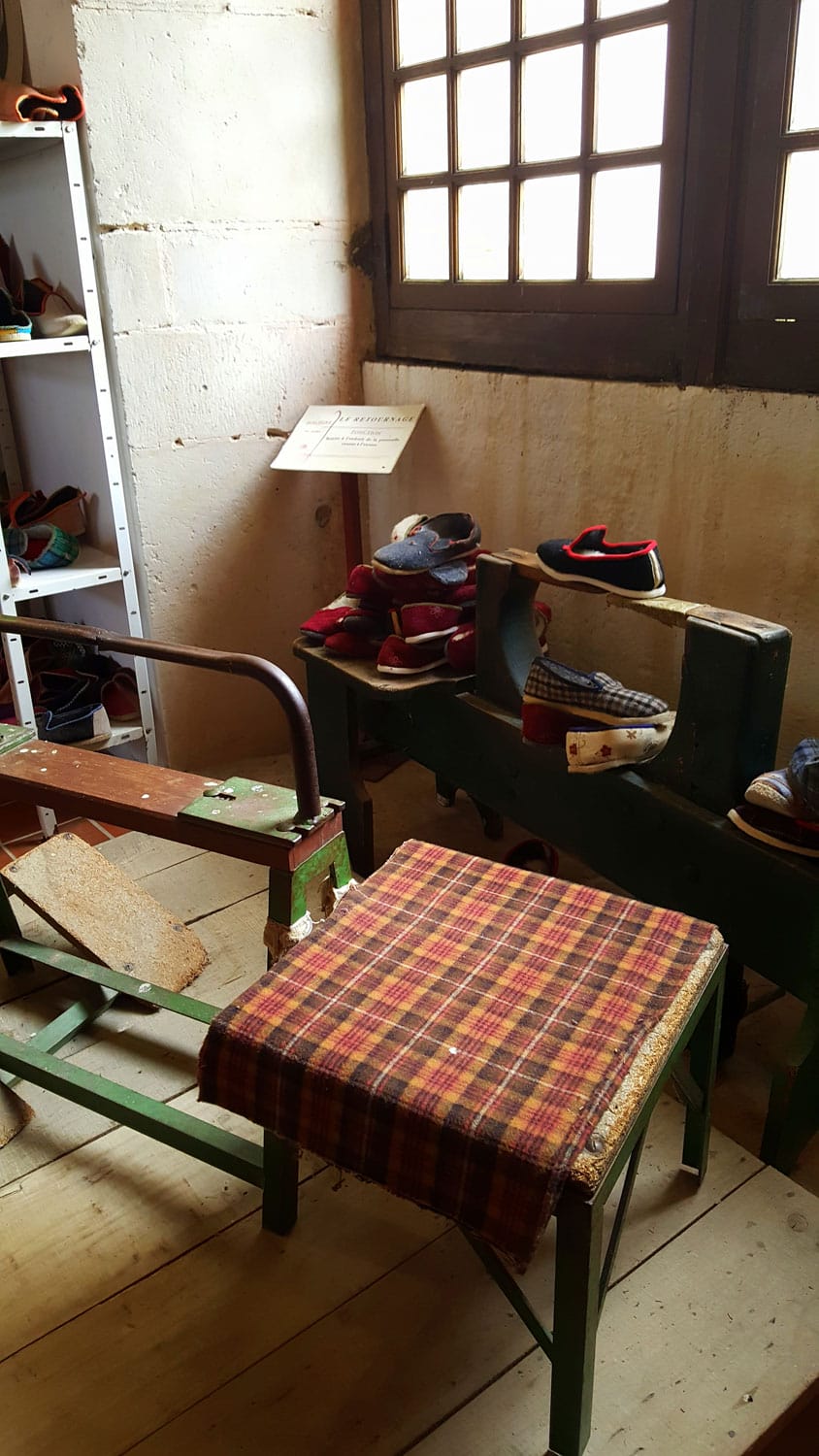 Atelier de sabotier reconstitué au musée de Varaignes avec ses chaises en bois et sa collection de chaussures traditionnelles