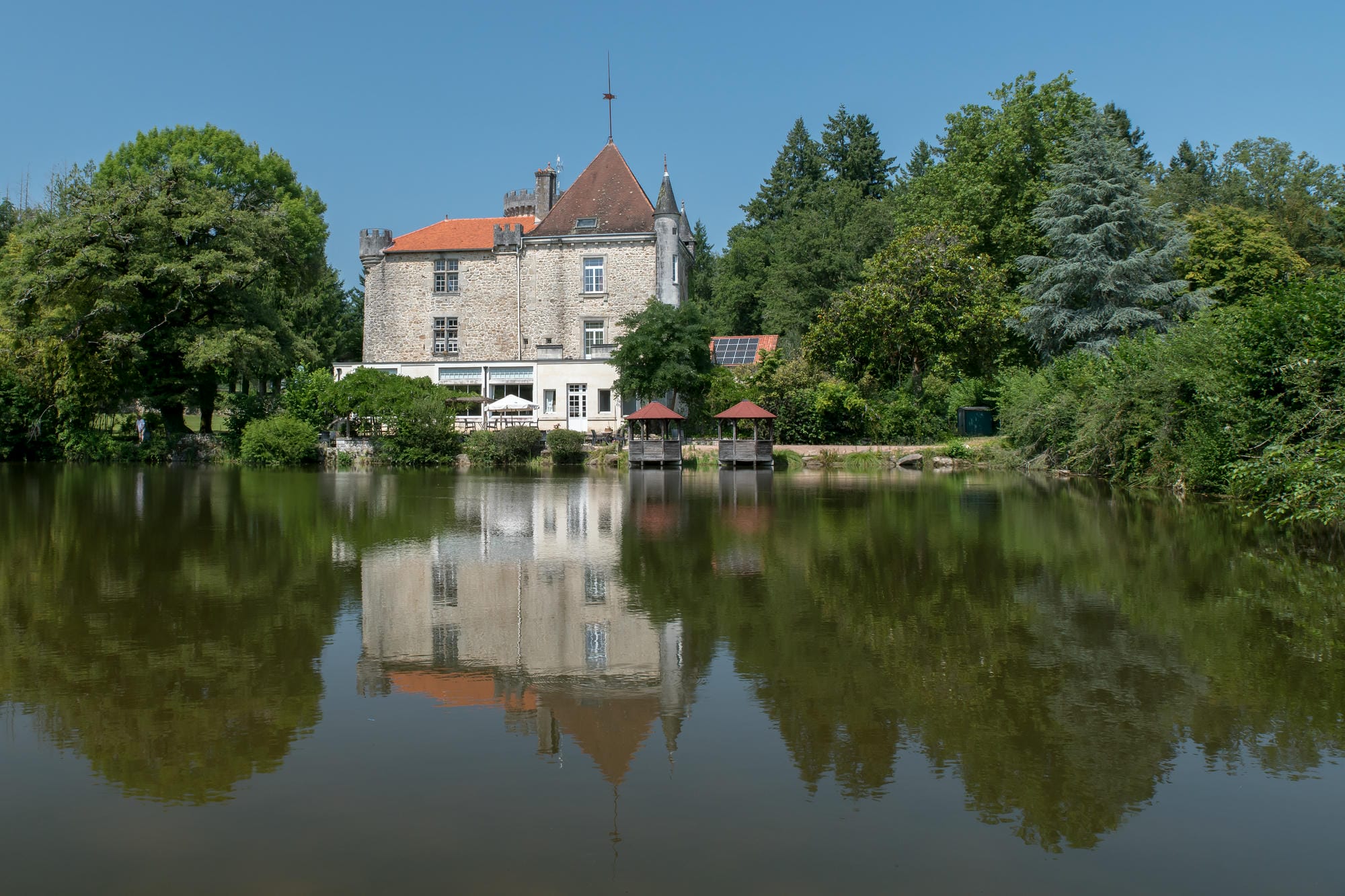 Le Château le Verdoyer majestueusement situé au bord de son étang de pêche