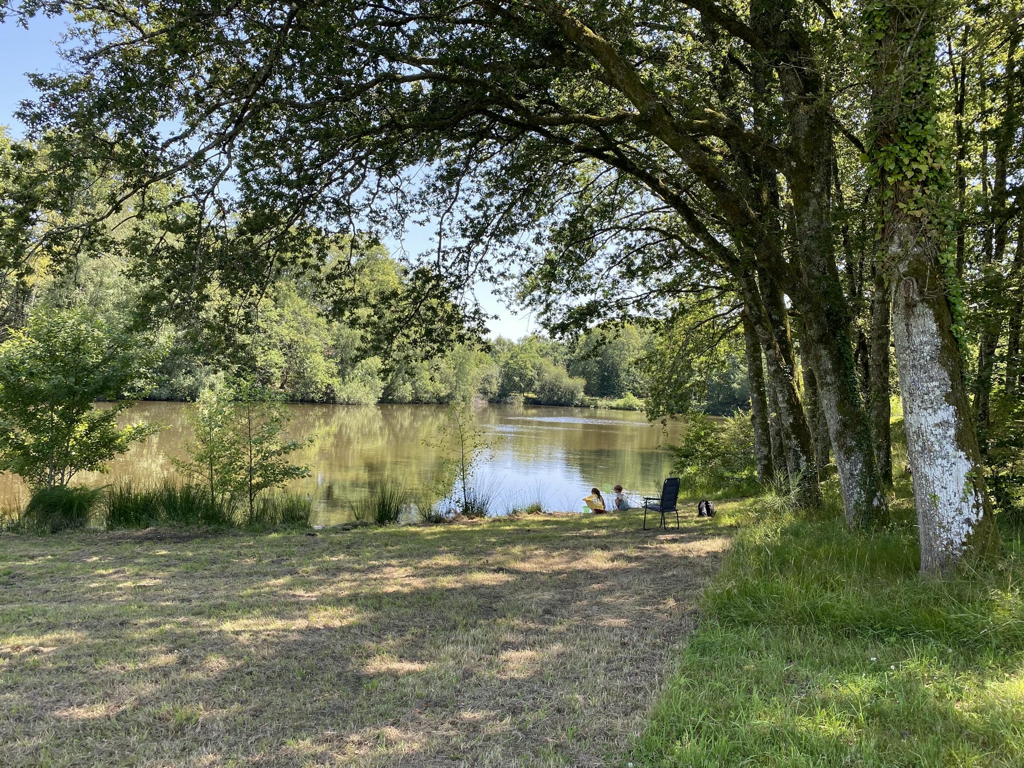 Quelques pêcheurs au bord de l'étang de pêche du Camping Château le Verdoyer