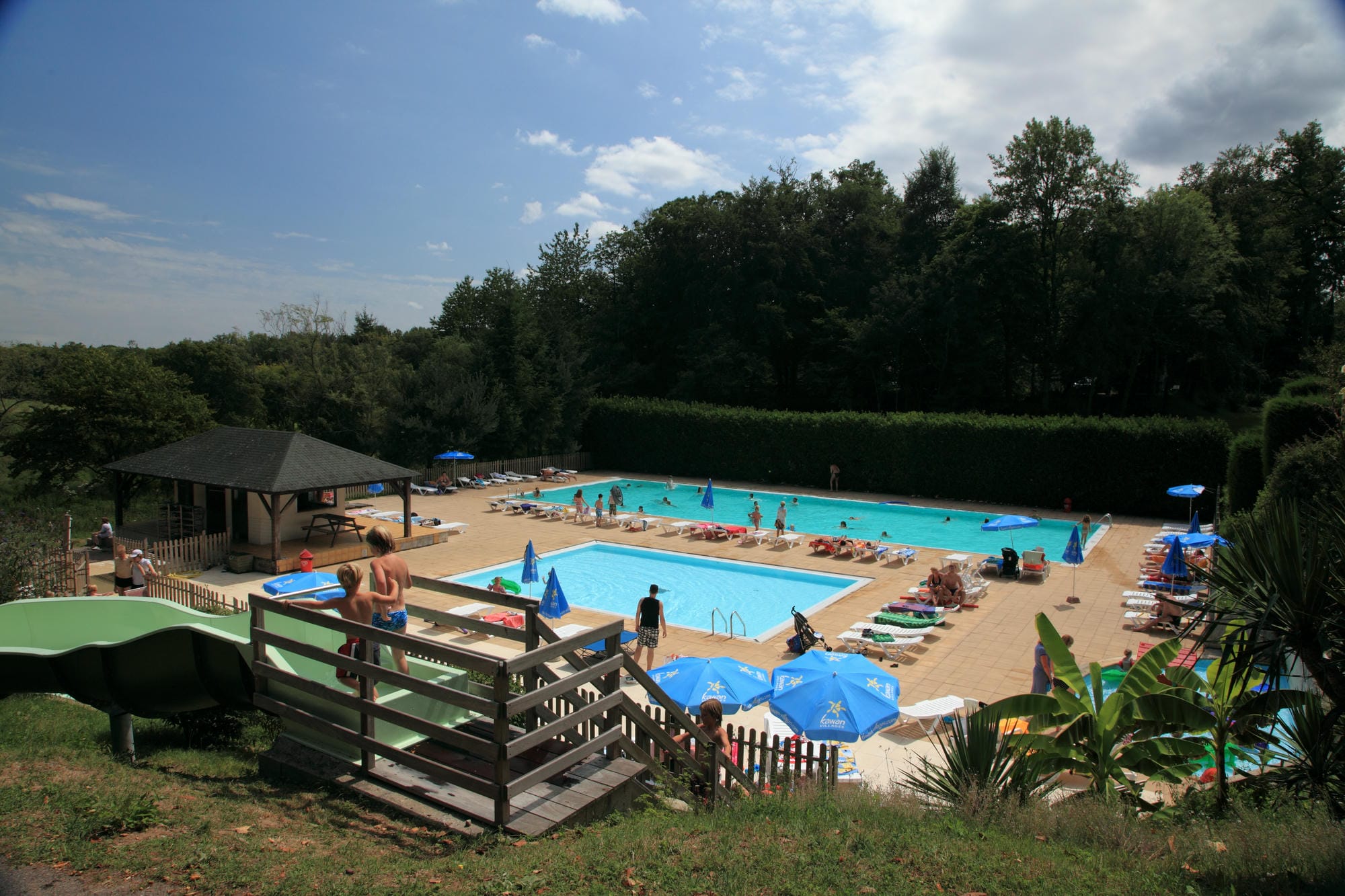 Nombreux vacanciers profitant du soleil à la piscine extérieure du Camping Château le Verdoyer