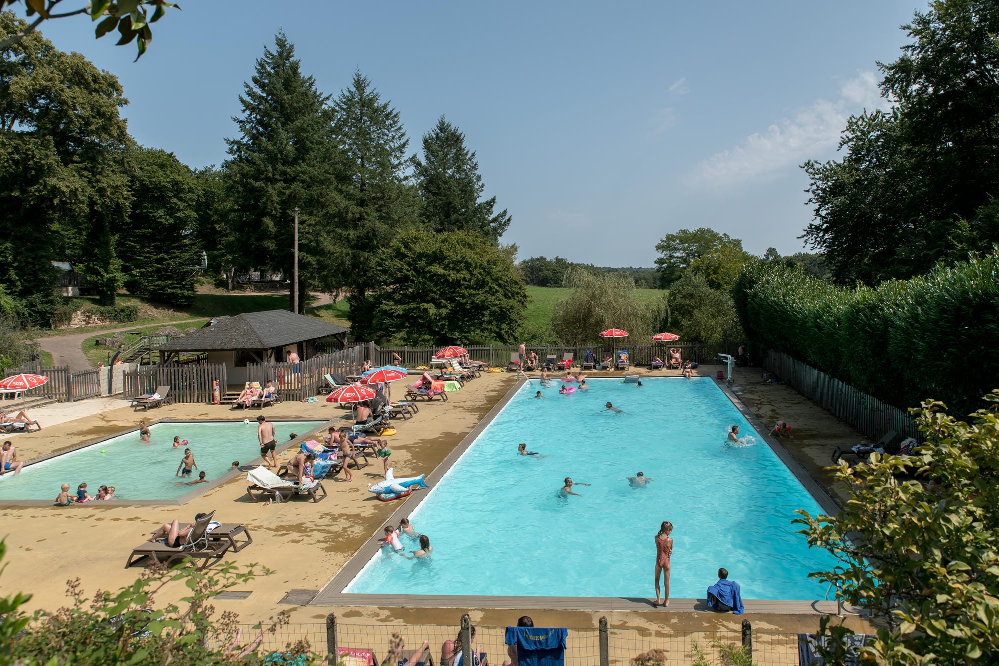 Vacanciers profitant du soleil et de la baignade à la piscine du Camping Château le Verdoyer