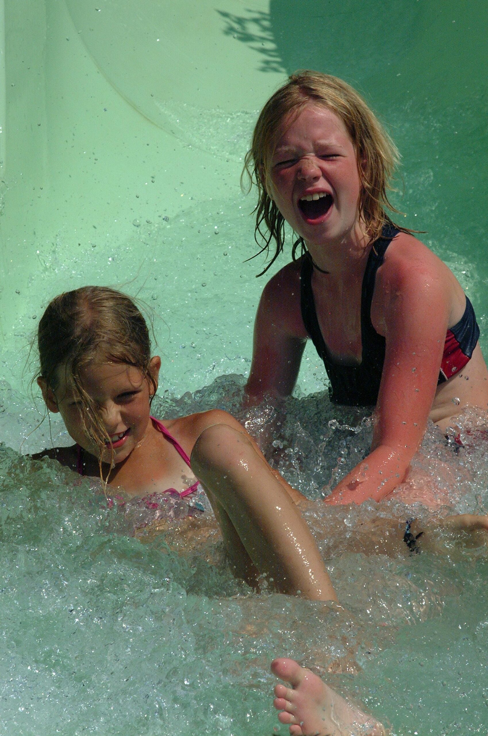 Enfants s'amusant dans l'eau sur le toboggan du parc aquatique au Château le Verdoyer