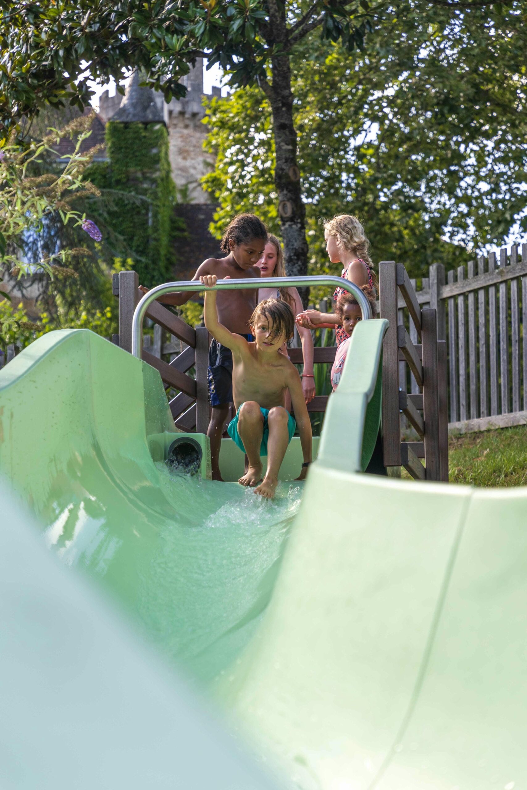 Enfants s'amusant sur le toboggan de la piscine du Camping Le Verdoyer