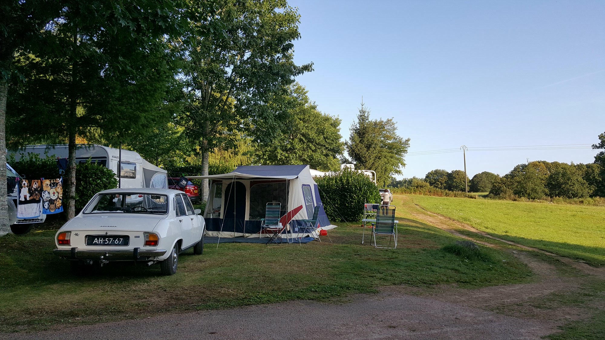 Peugeot rétro garé devant une tente sur un emplacement de camping au Verdoyer