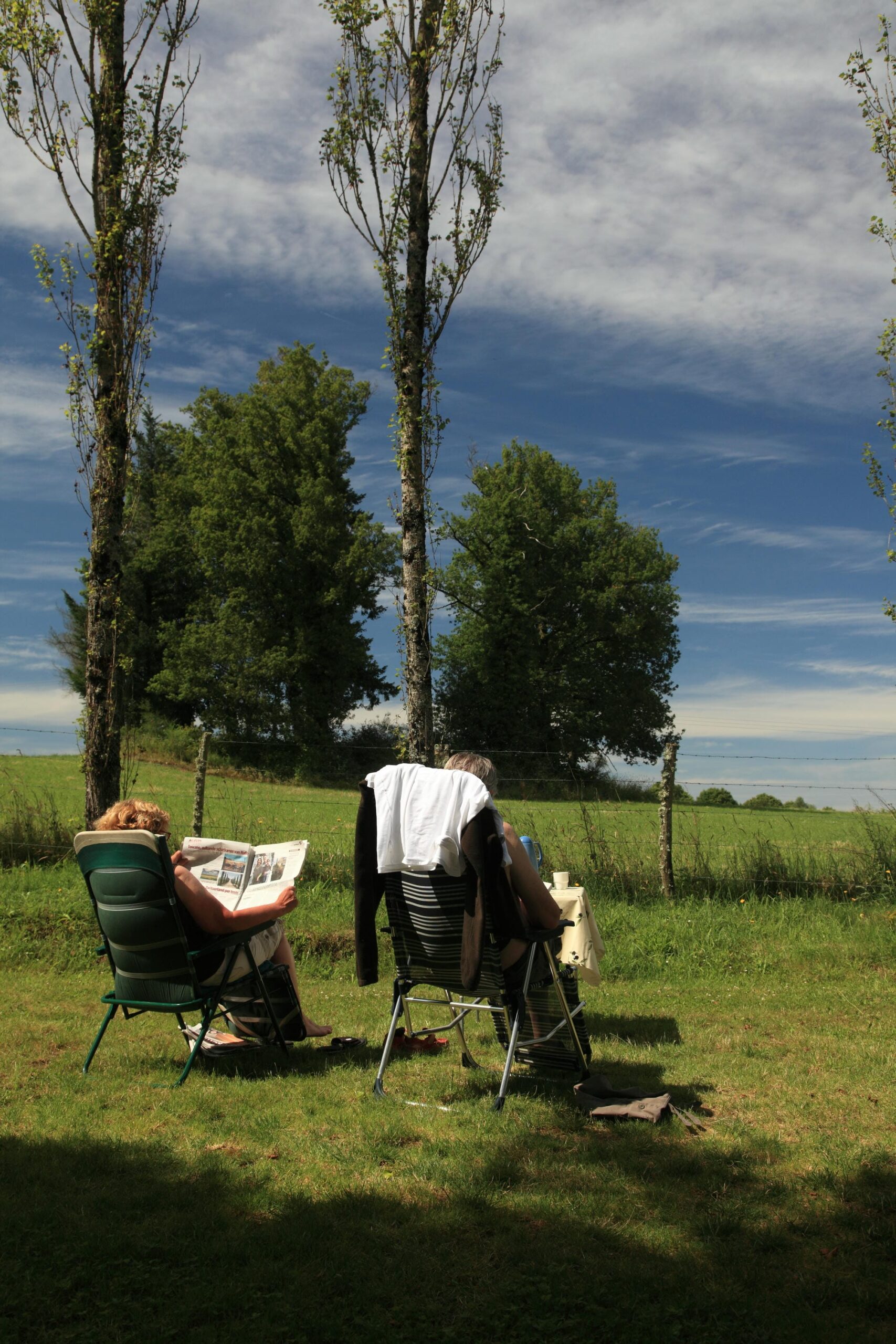 Couple assis sur des transats sur un emplacement de camping ensoleillé au Verdoyer
