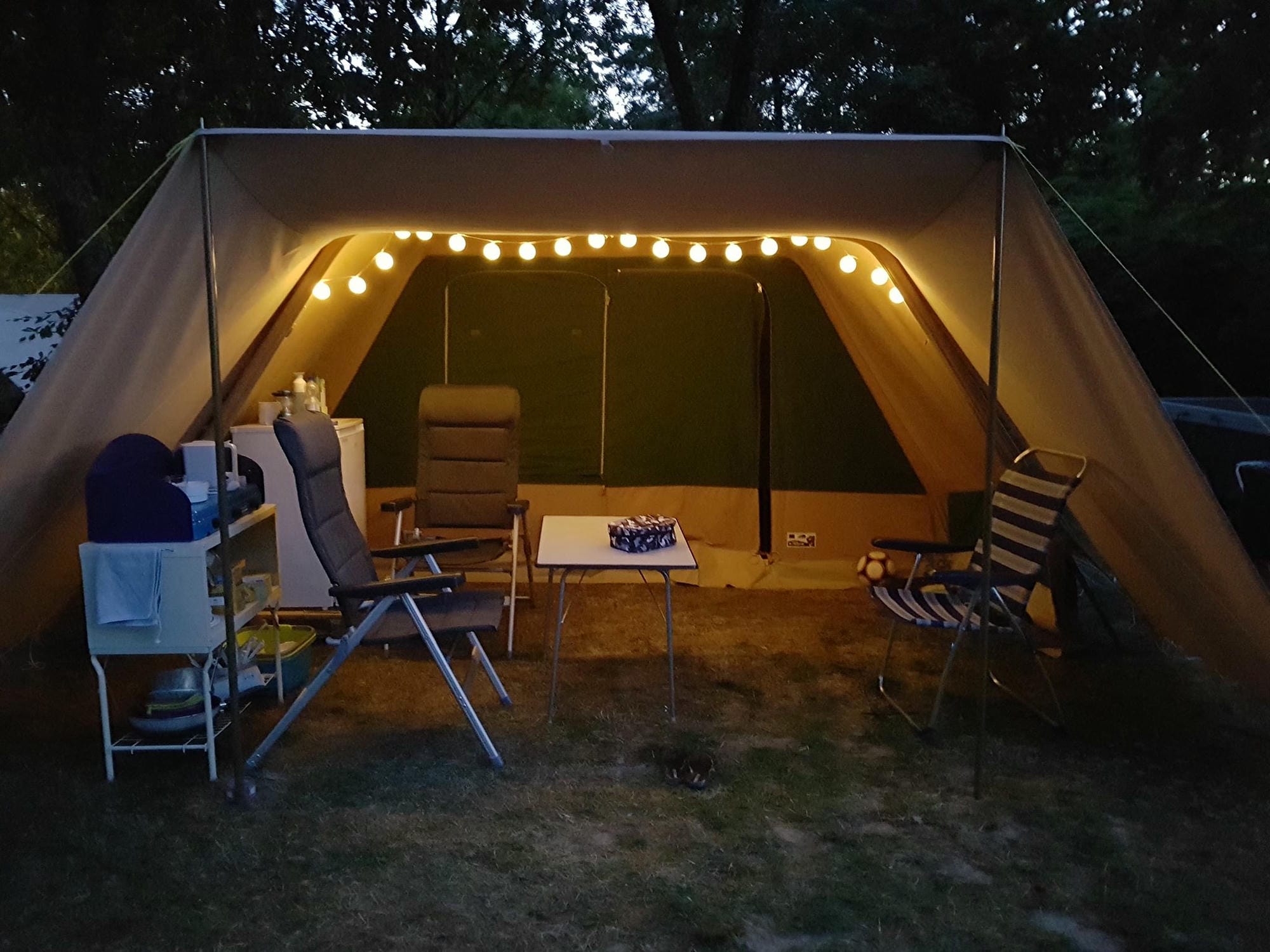 Tente avec table et chaises à l'intérieur, confort en camping au Château le Verdoyer