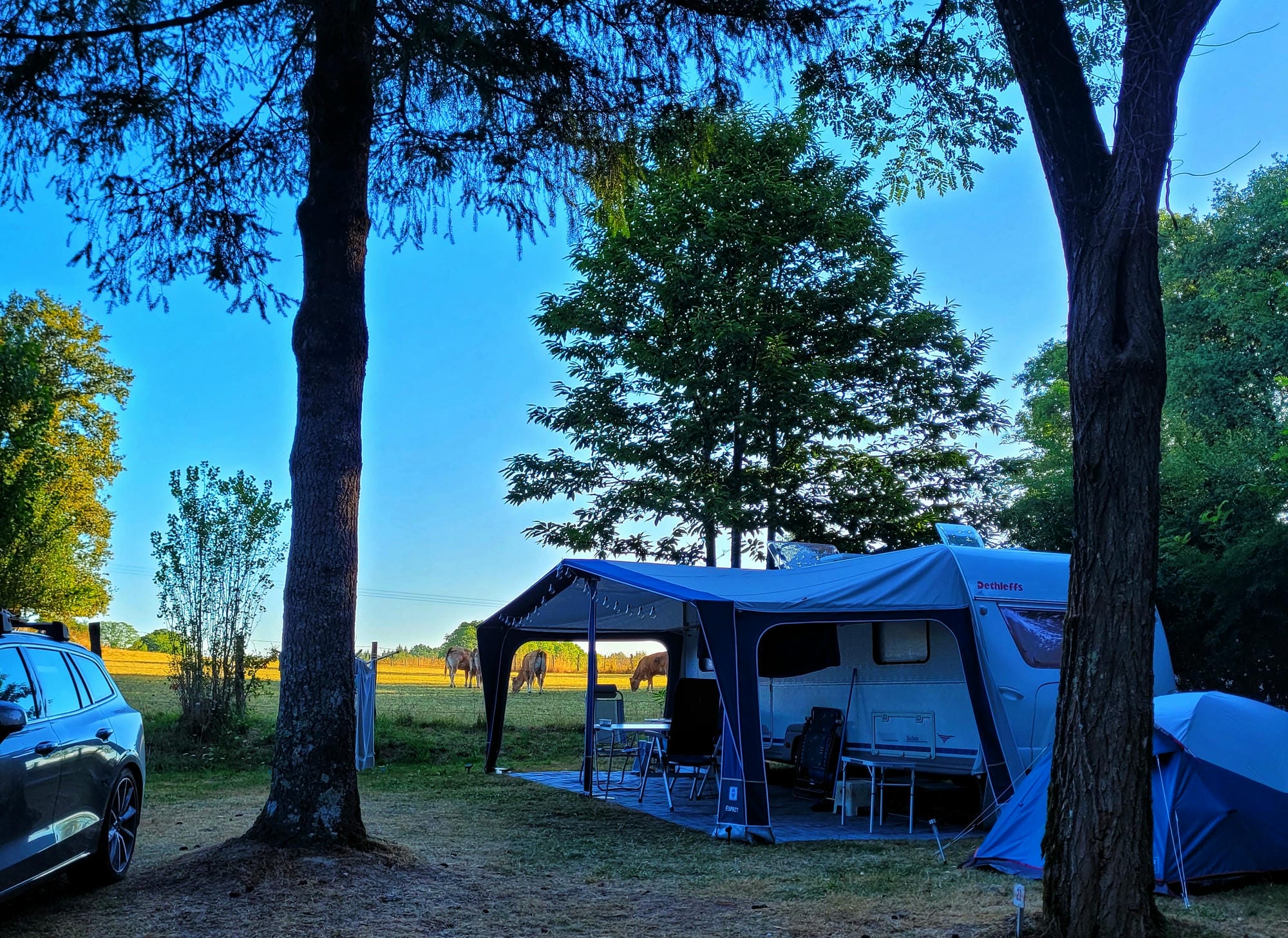 Voiture et caravane avec auvent, emplacement de camping au Verdoyer