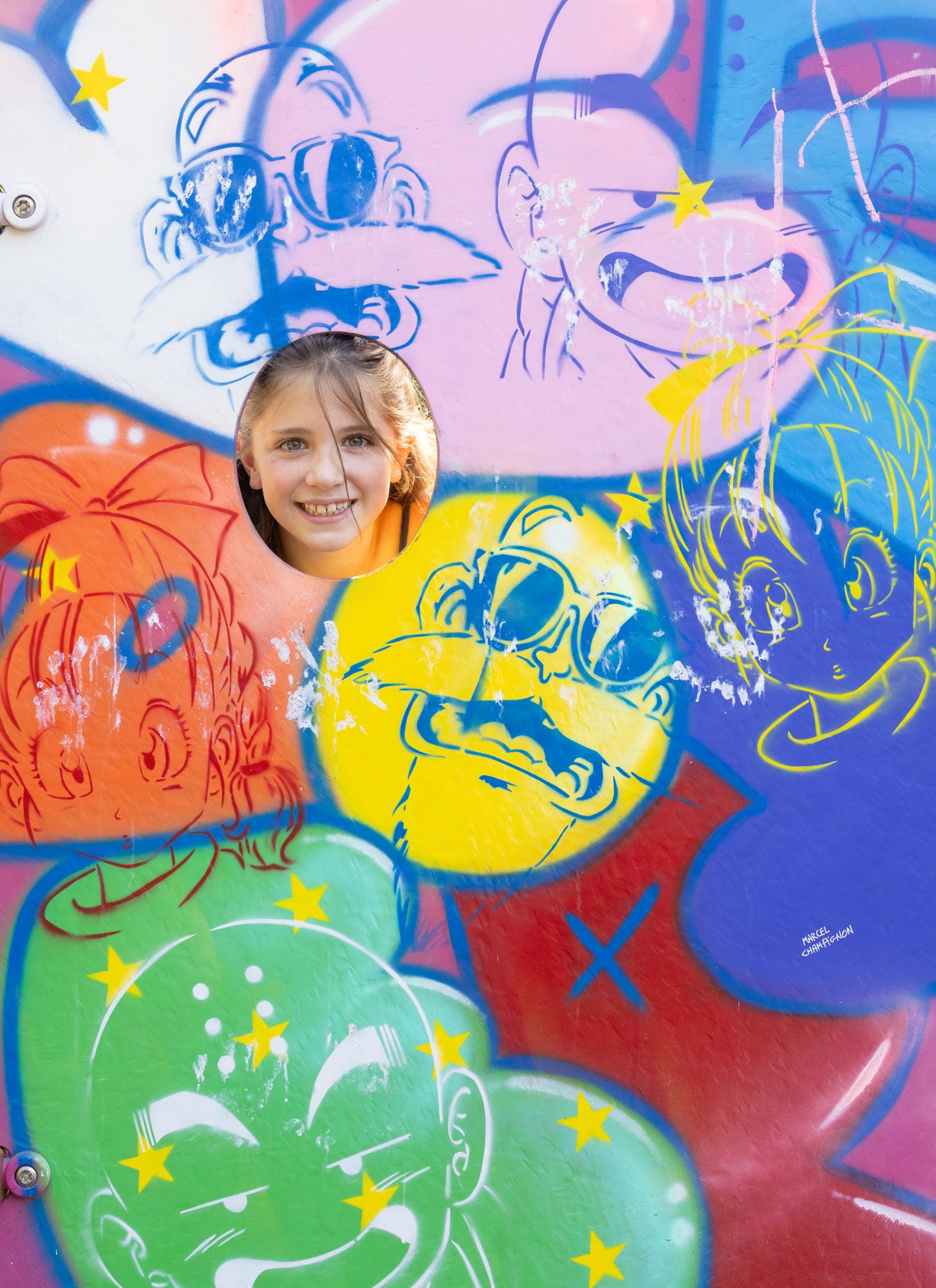 Enfant s'amusant dans le décor coloré de l'aire de jeux thématisée au Château le Verdoyer