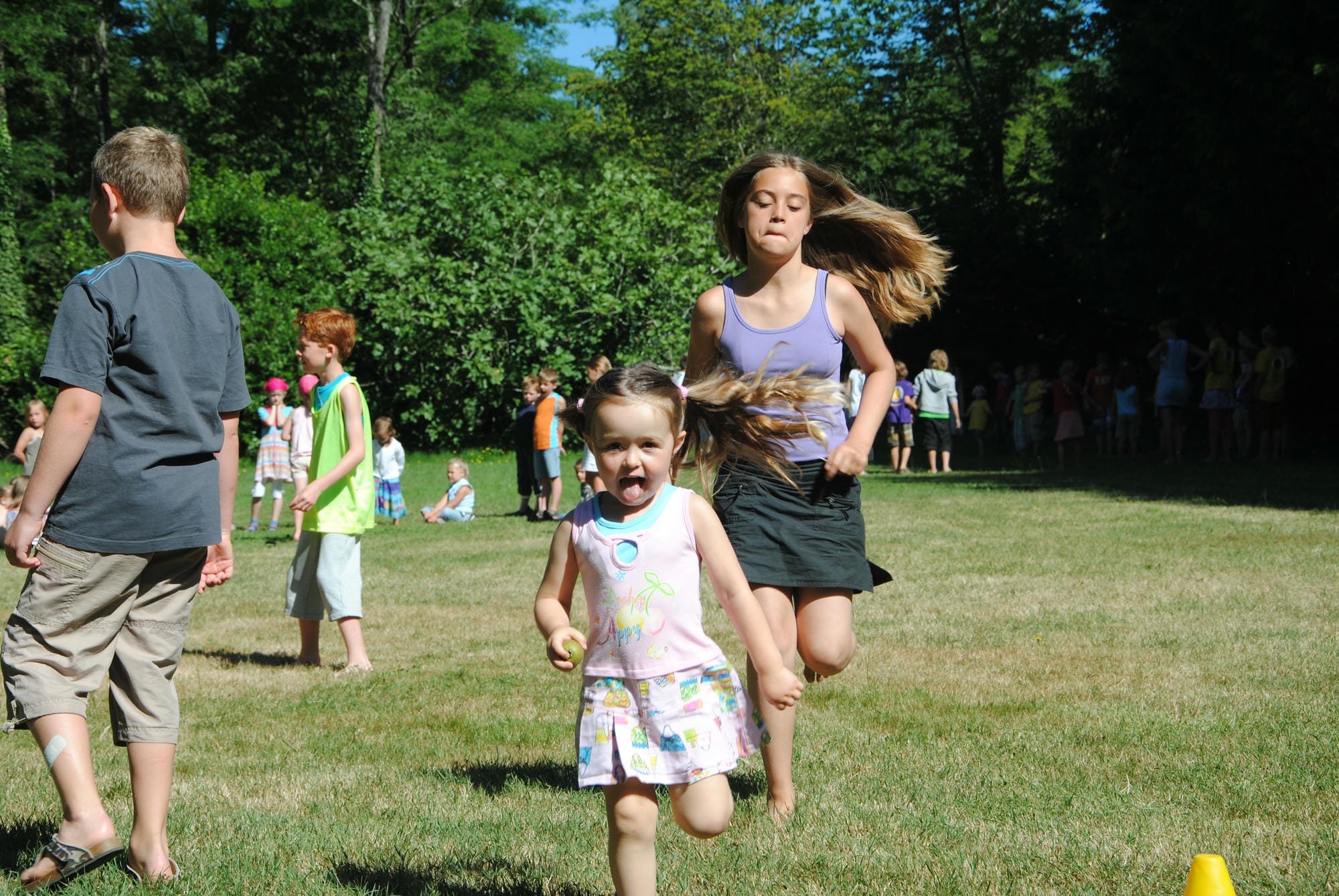 Deux jeunes enfants courant dans la prairie, jeux de plein air au club Lenny du Verdoyer