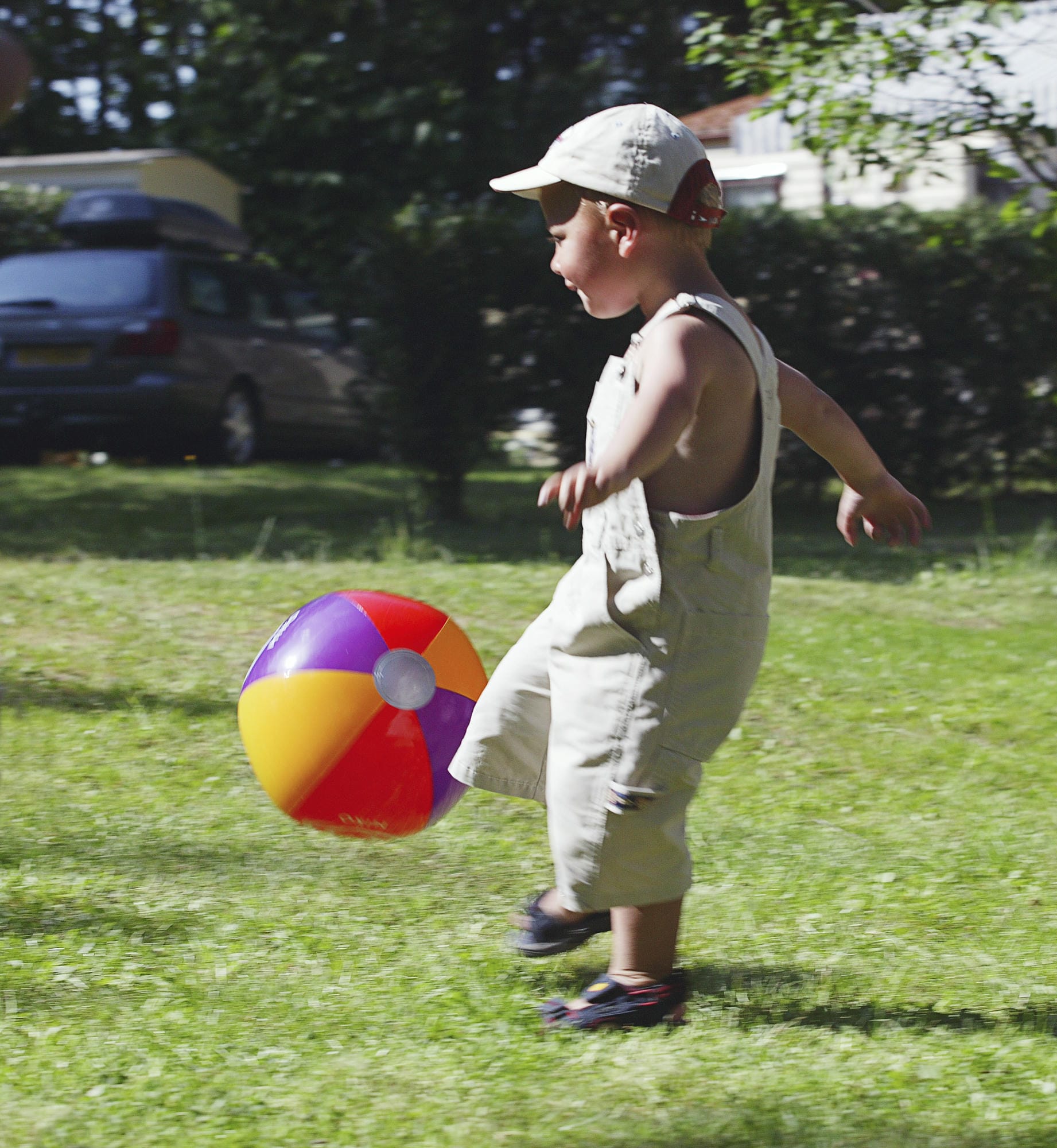 Jeune garçon jouant avec un ballon de plage dans le jardin, club enfants au Verdoyer