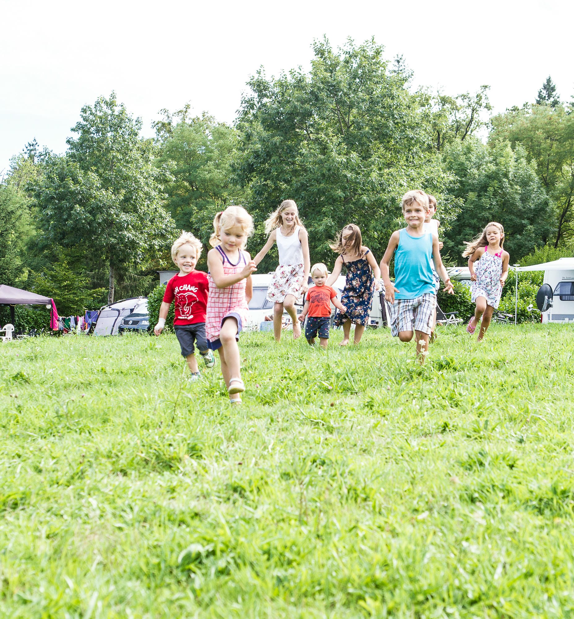 Course d'enfants dans l'herbe, activité énergique au club Lenny du Camping Le Verdoyer