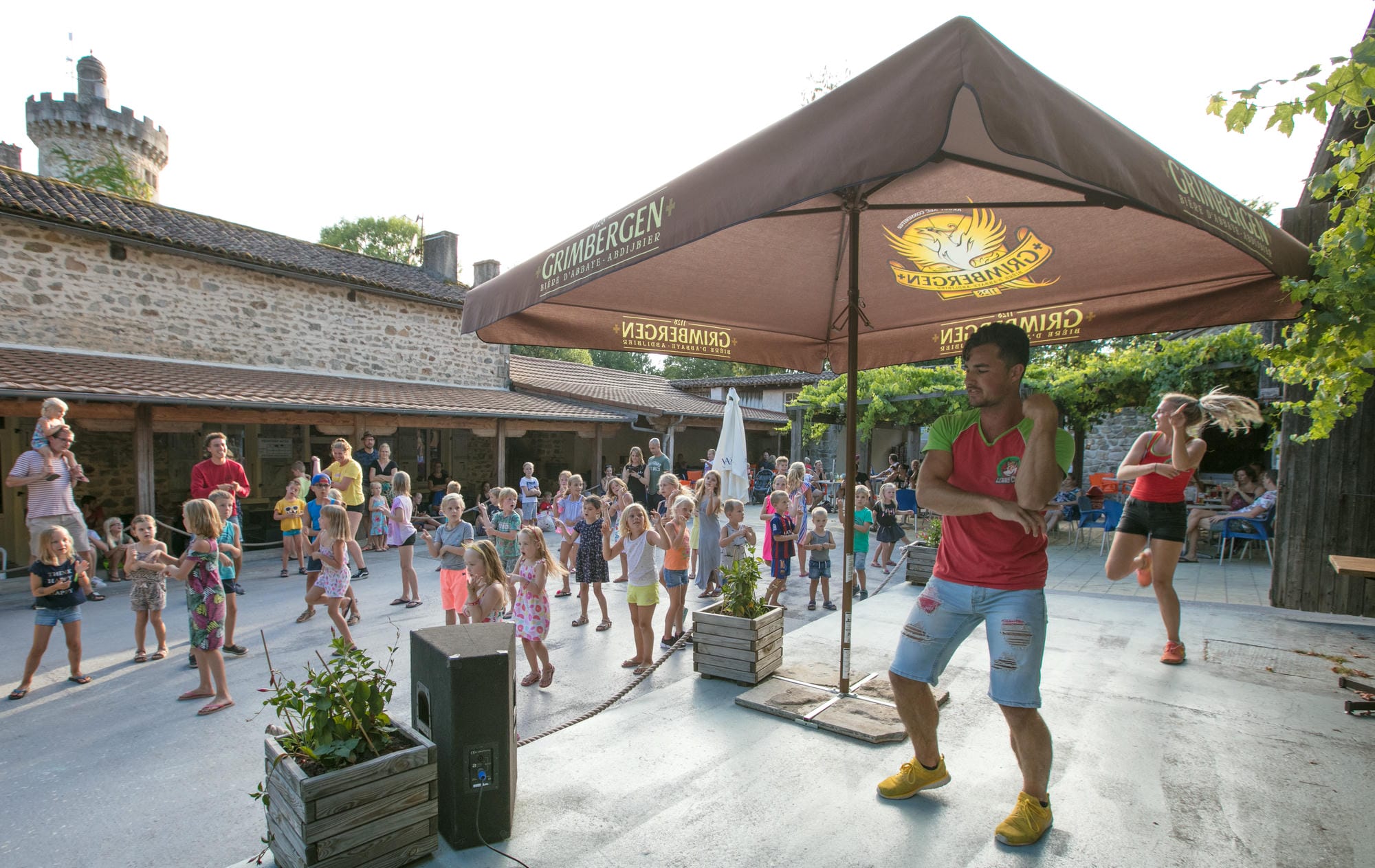 Animateur sous un parasol lors de la mini disco au club enfants du Château le Verdoyer