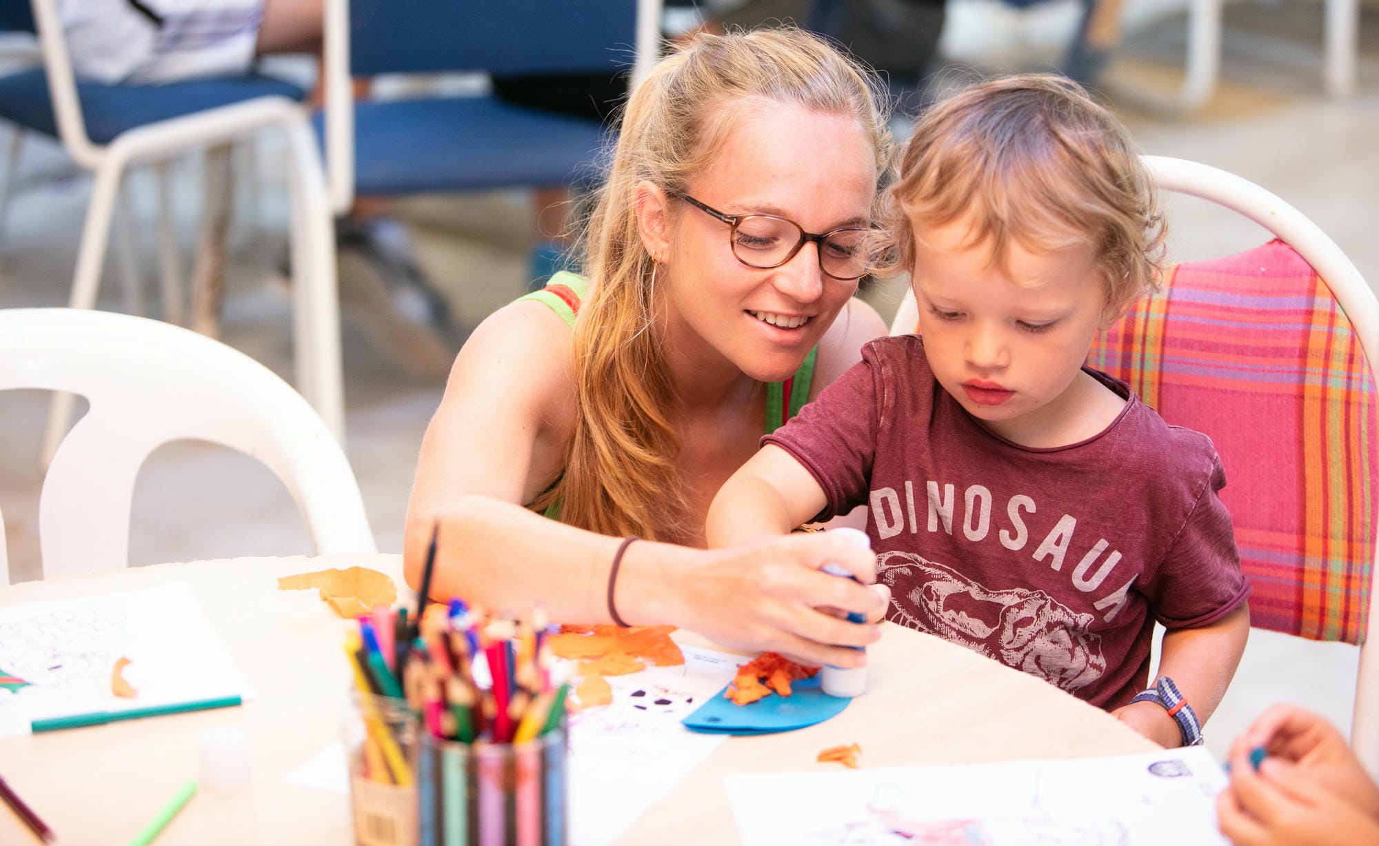 Animatrice et enfant participant à une activité manuelle au club enfants du Château le Verdoyer