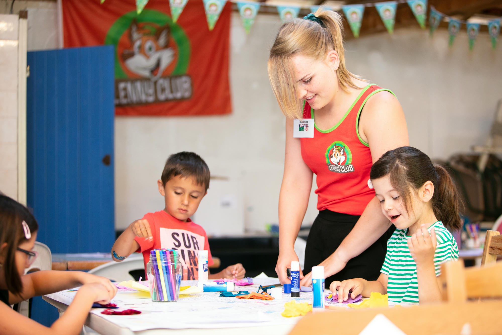 Enfants assis à une table avec une animatrice, atelier au club Lenny du Verdoyer