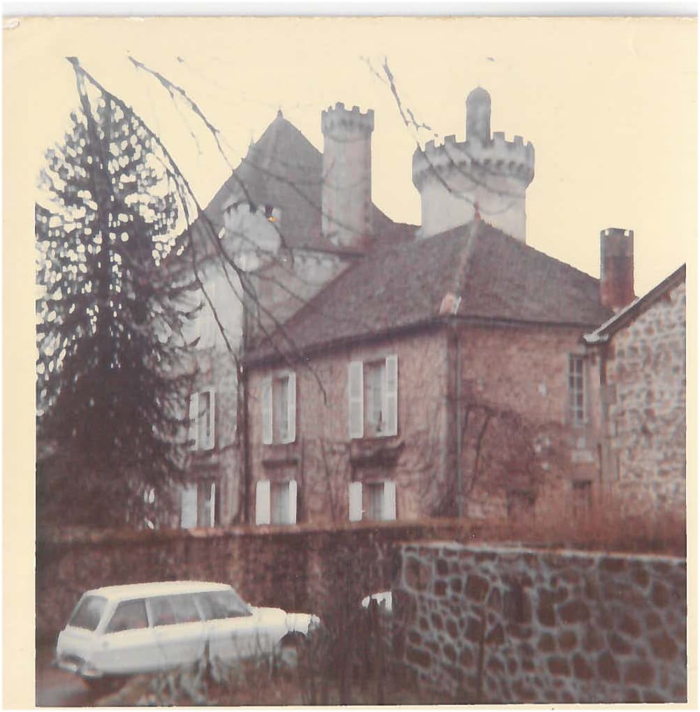 Photographie vintage du château avec voiture blanche, feuillage d'automne, murs en pierre