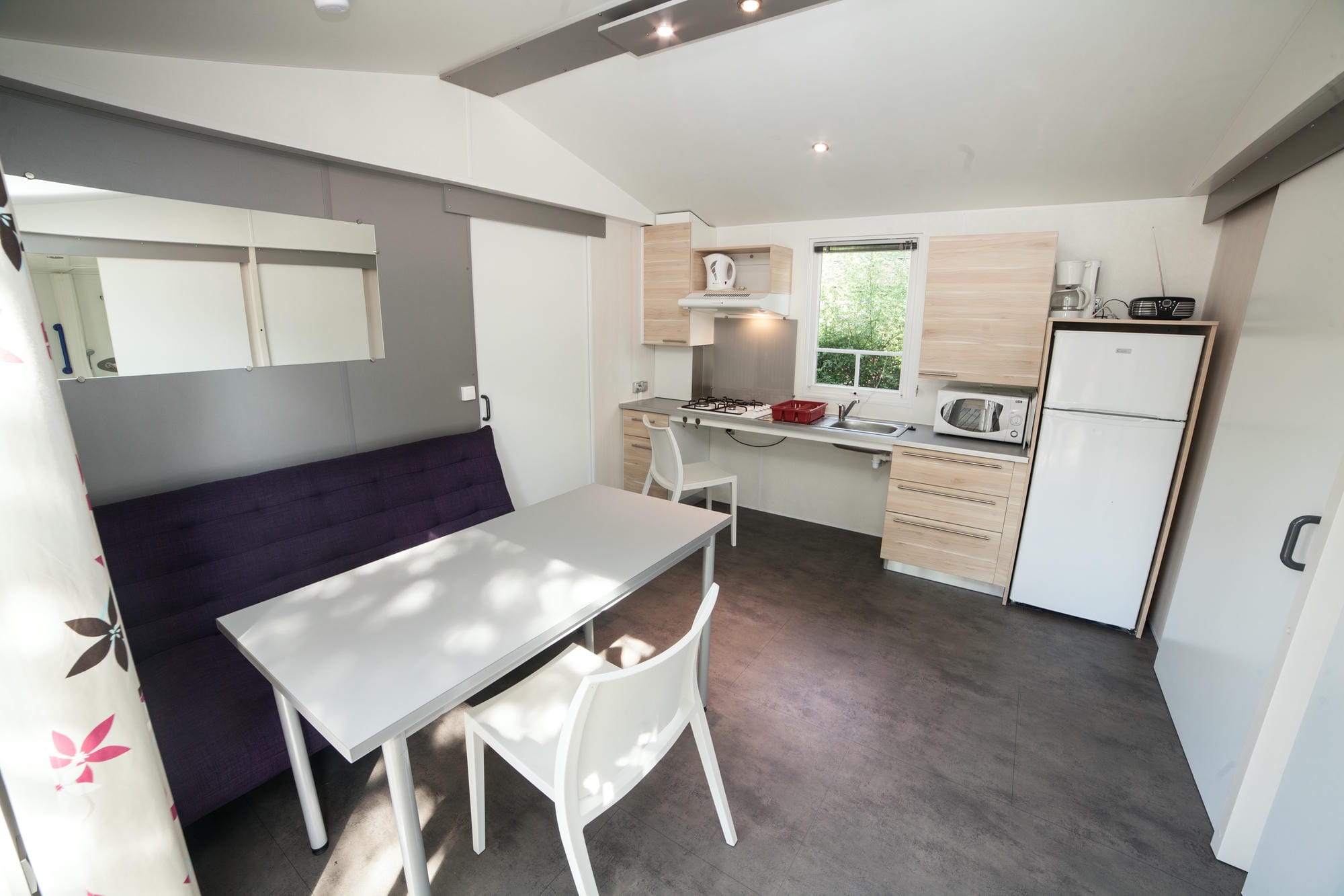 Cuisine équipée avec table et chaises dans un mobil-home LIFE adapté PMR au Château le Verdoyer