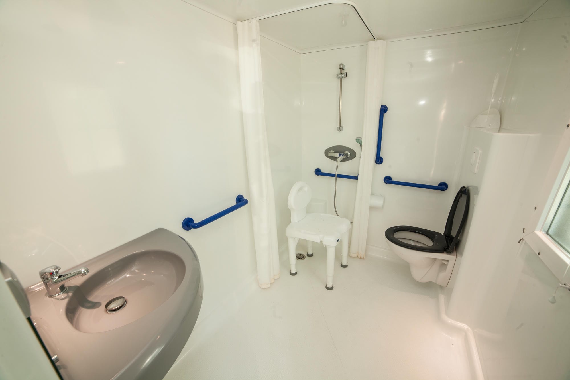 Salle de bain adaptée PMR avec WC, lavabo et douche dans un mobil-home LIFE