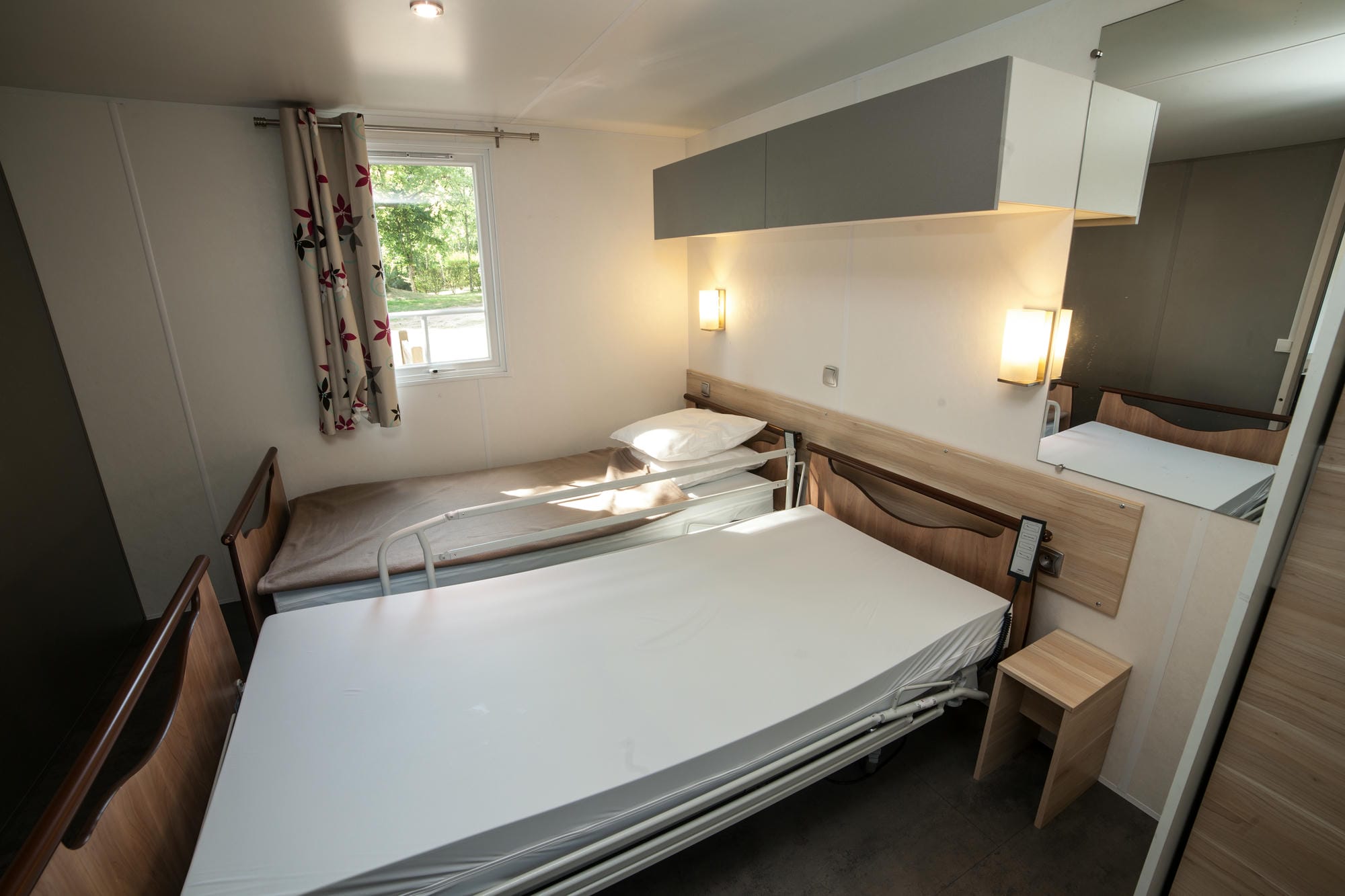Chambre avec lit et bureau dans un mobil-home LIFE adapté PMR, Camping Le Verdoyer