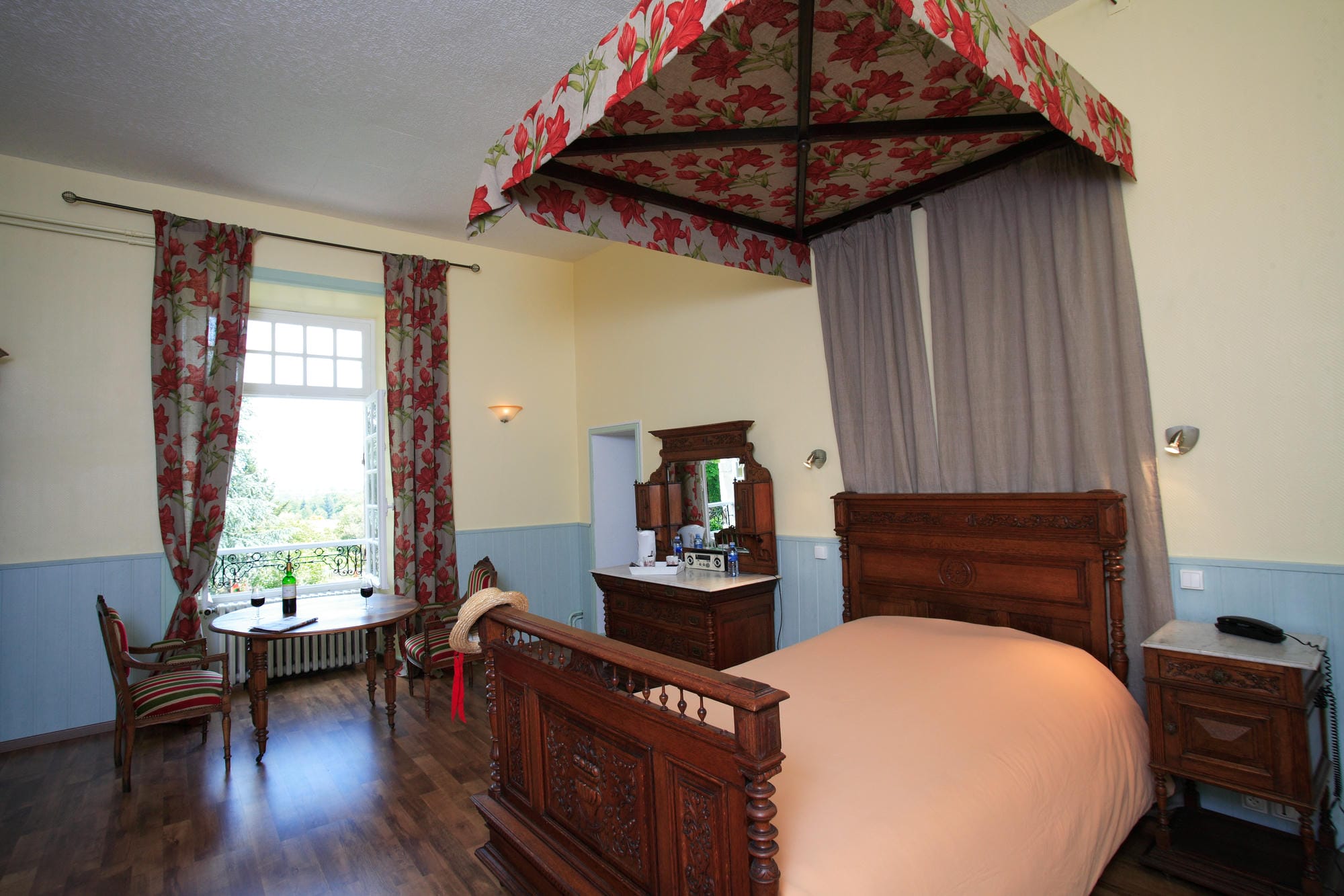 Chambre 11 au Château le Verdoyer : lit à baldaquin, table et chaises pour une ambiance romantique