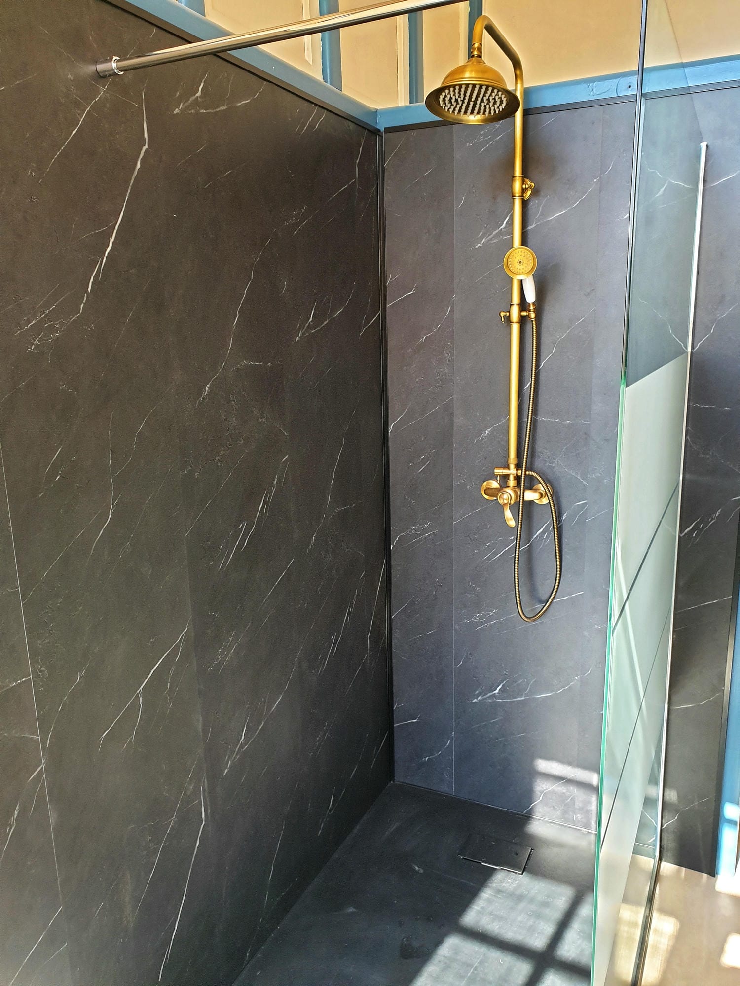 Douche avec pommeau doré et porte vitrée, salle de bain chambre 11 au Château le Verdoyer