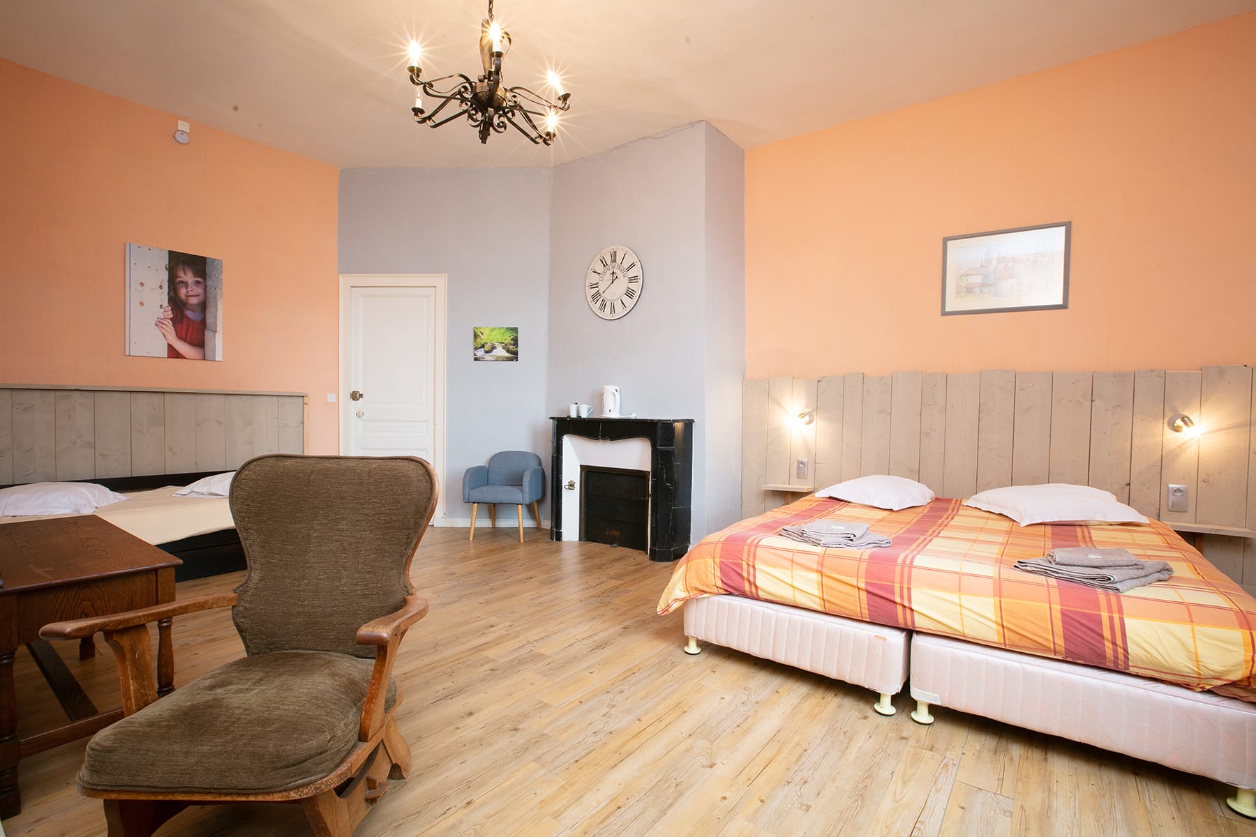 Chambre 23 au Château le Verdoyer : lit et fauteuil dans une pièce avec parquet en bois