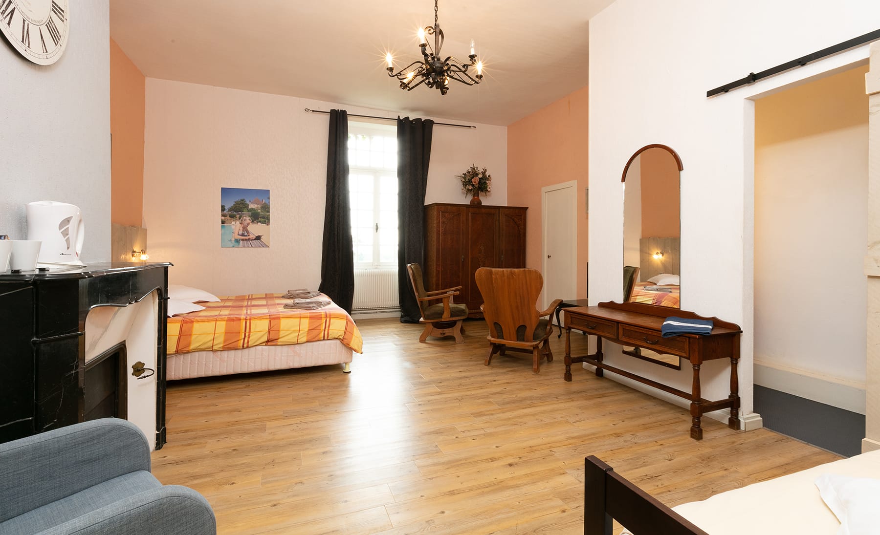 Chambre 23 au Château le Verdoyer : aménagement complet avec lit, bureau, chaise et miroir