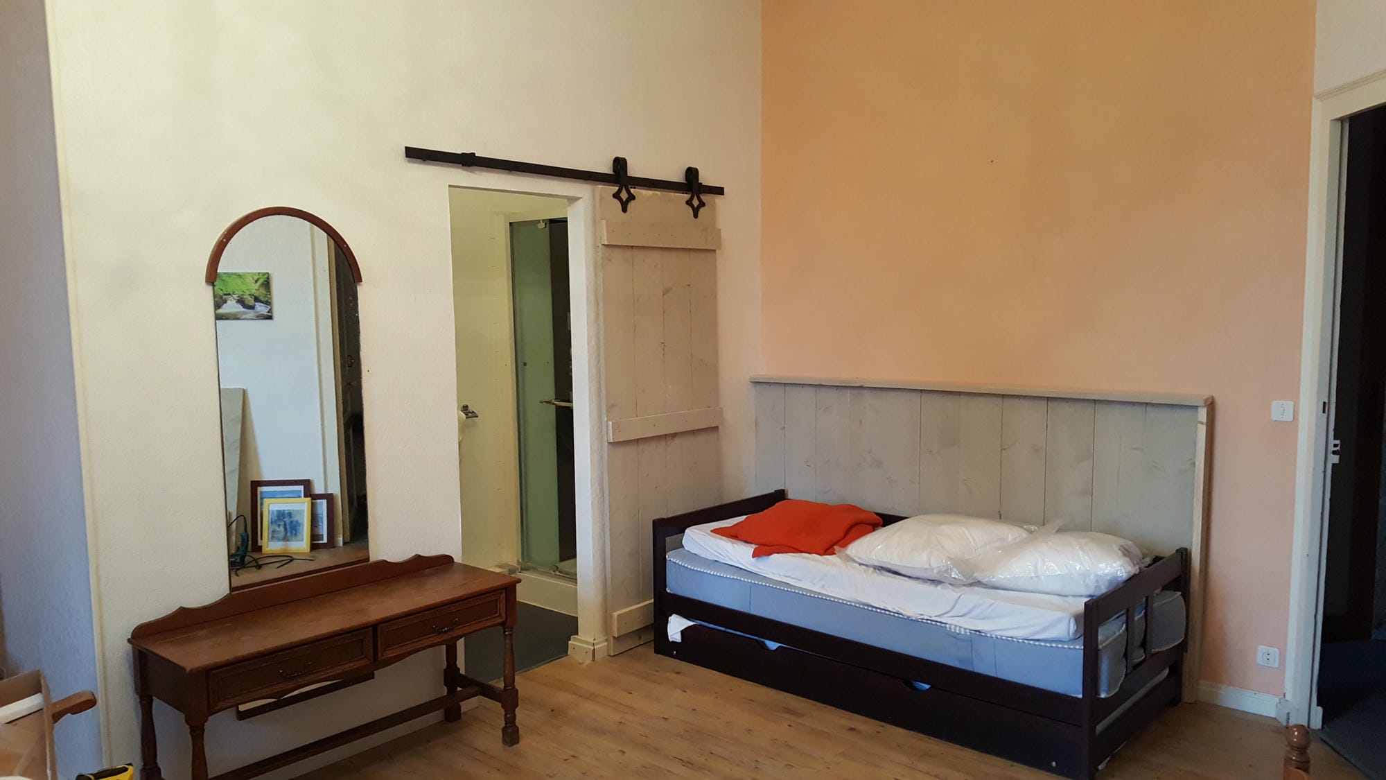 Chambre 23 au Château le Verdoyer : lit avec cadre en bois et miroir d'angle