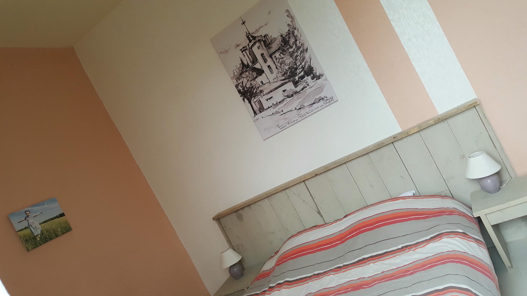 Chambre 24 au Château le Verdoyer : lit avec couverture rayée, table de nuit et lampe