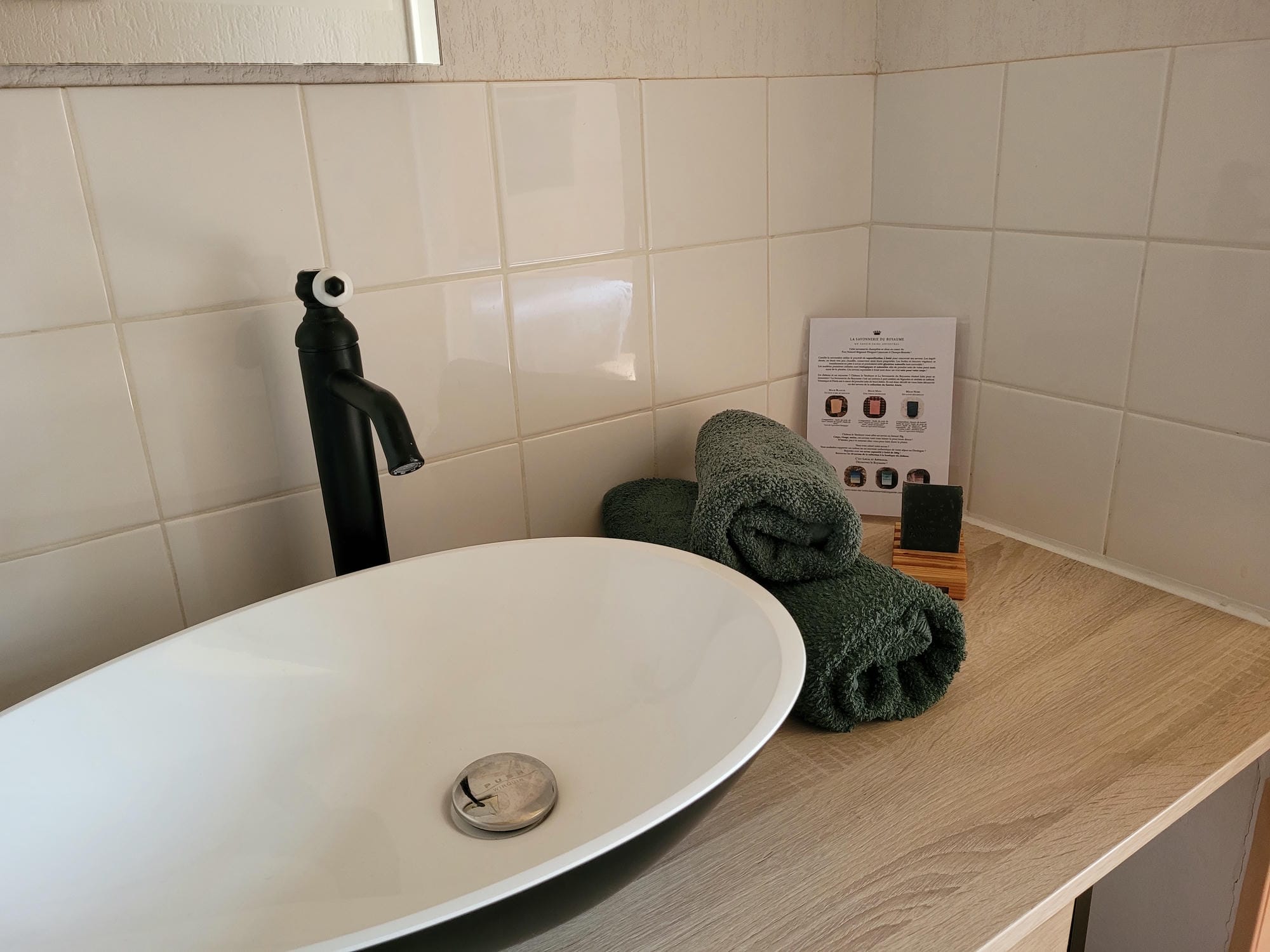 Lavabo blanc sur un comptoir en bois dans la salle de bain de la chambre 24 au Château
