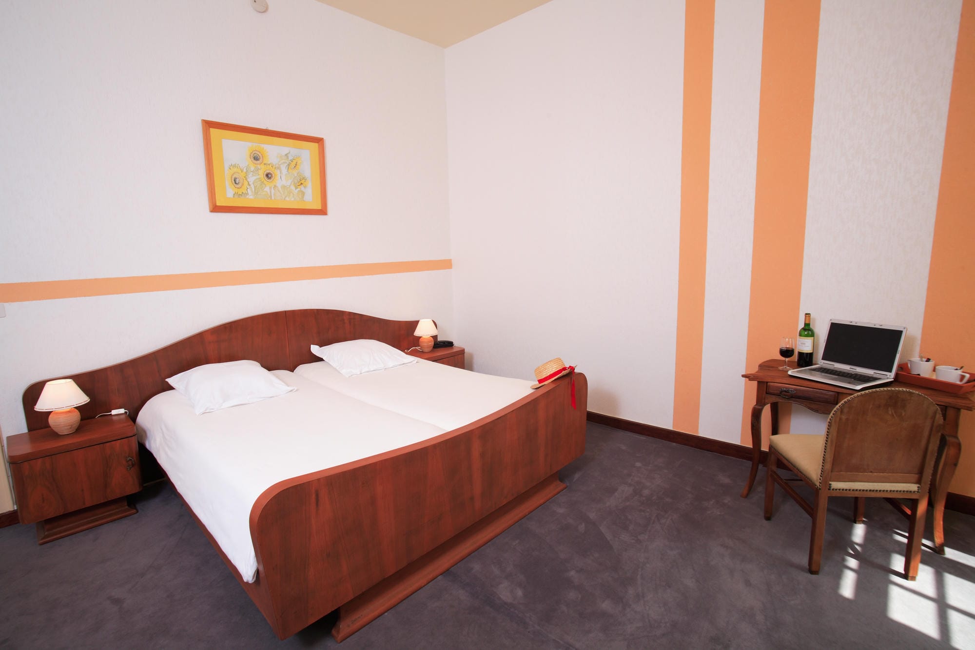 Chambre 25 au Château le Verdoyer : lit et bureau dans une pièce aux murs orange