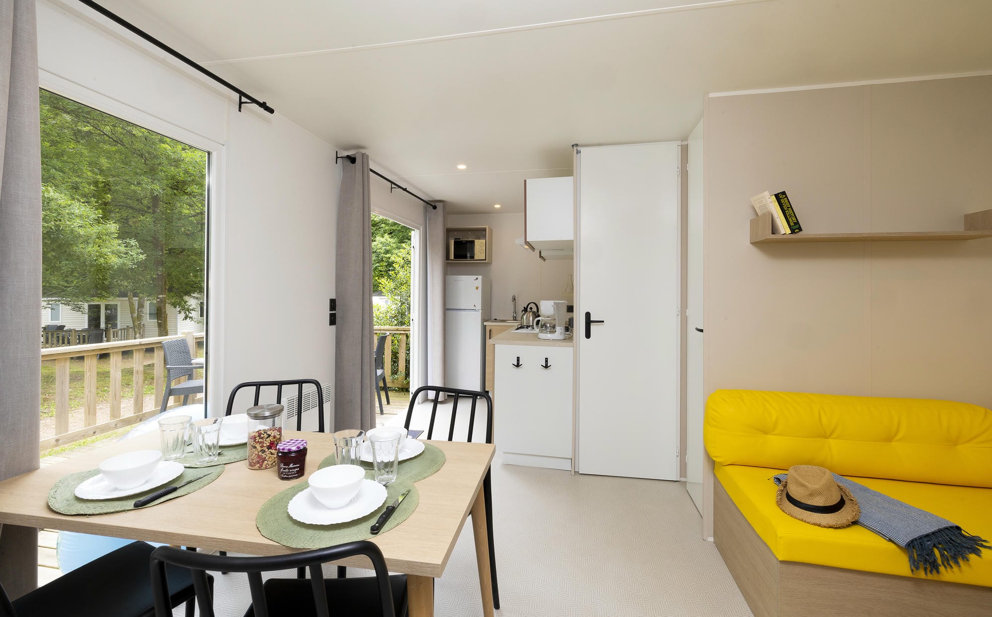 Salon lumineux et salle à manger du mobil-home luxe avec accès terrasse au Château le Verdoyer