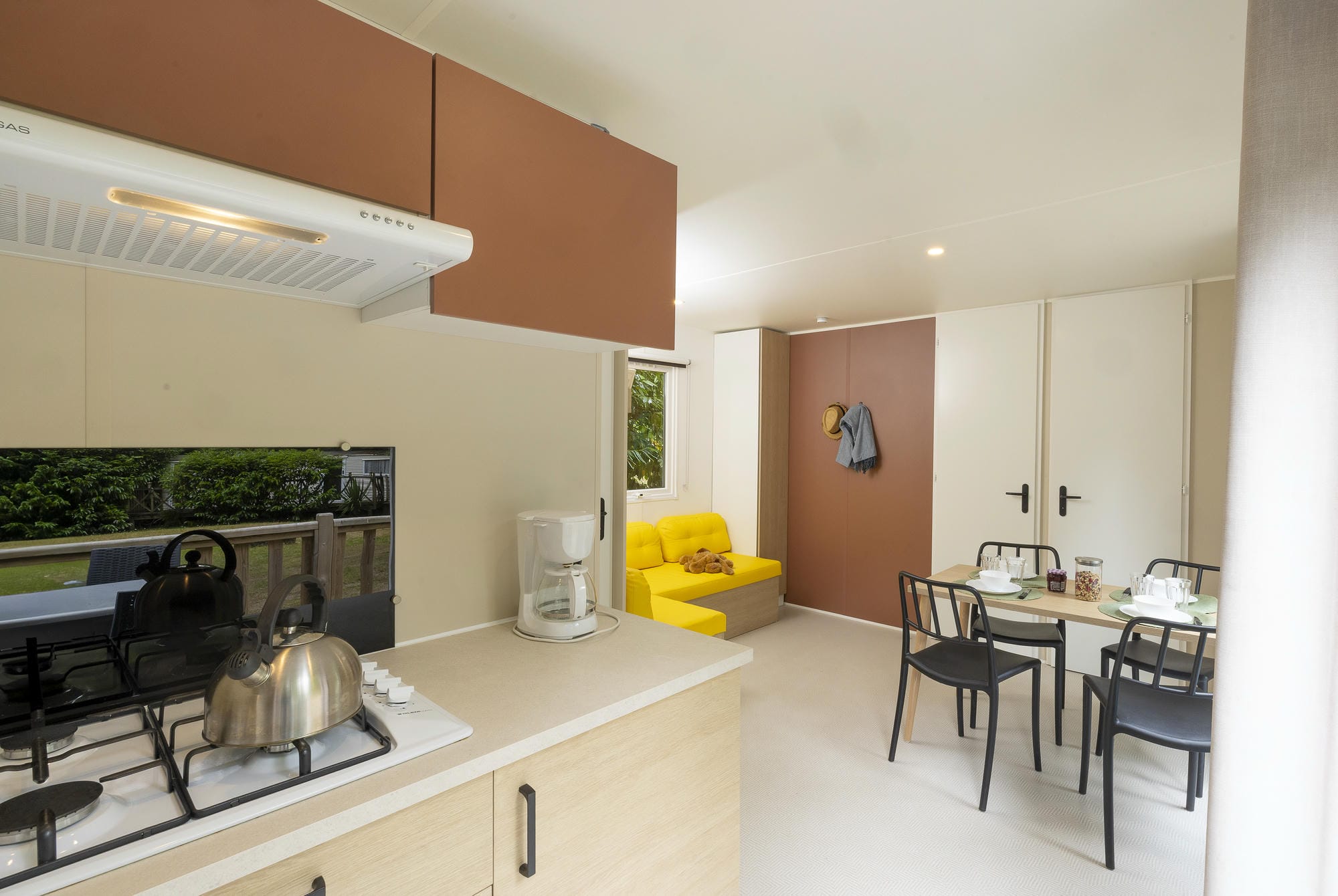 Cuisine ouverte moderne avec coin repas et salon dans le mobil-home luxe au Château le Verdoyer