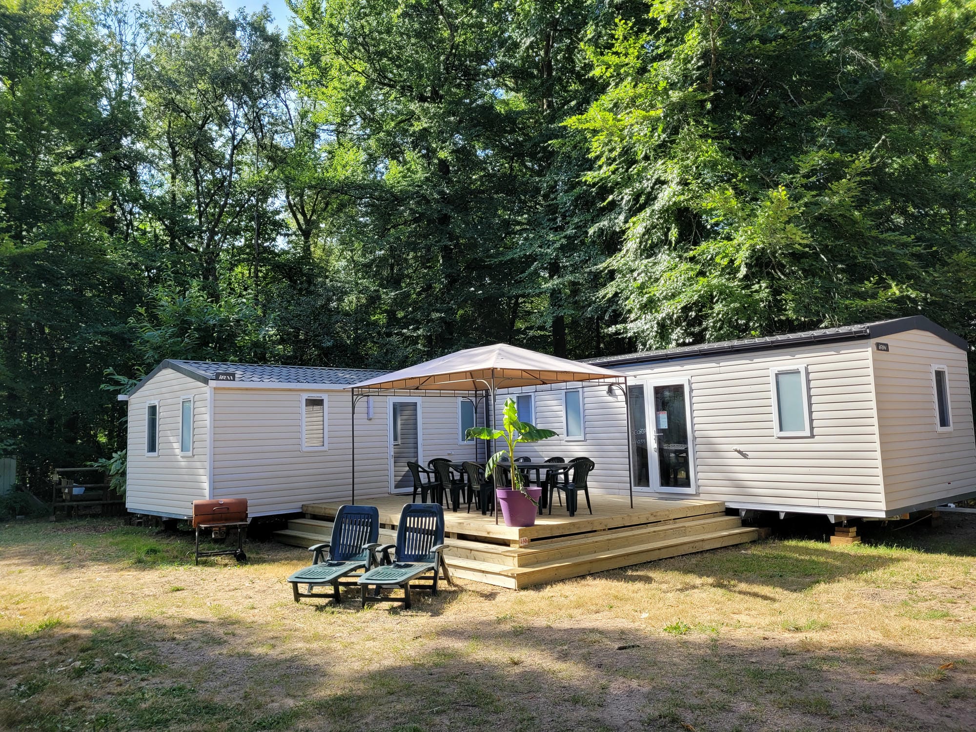 Mobil-home XXL avec terrasse, table et chaises, hébergement spacieux au Château le Verdoyer