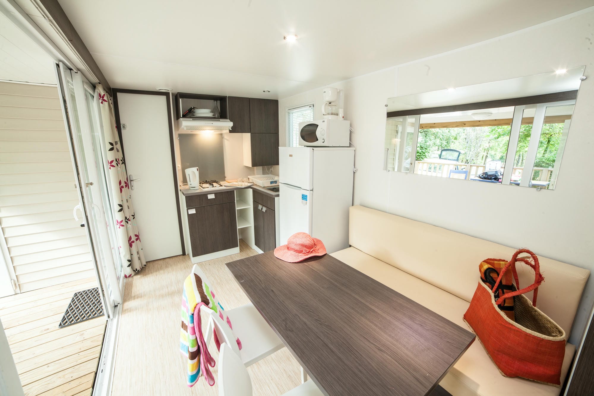 Coin cuisine avec table et canapé dans un mobil-home au Camping Château le Verdoyer