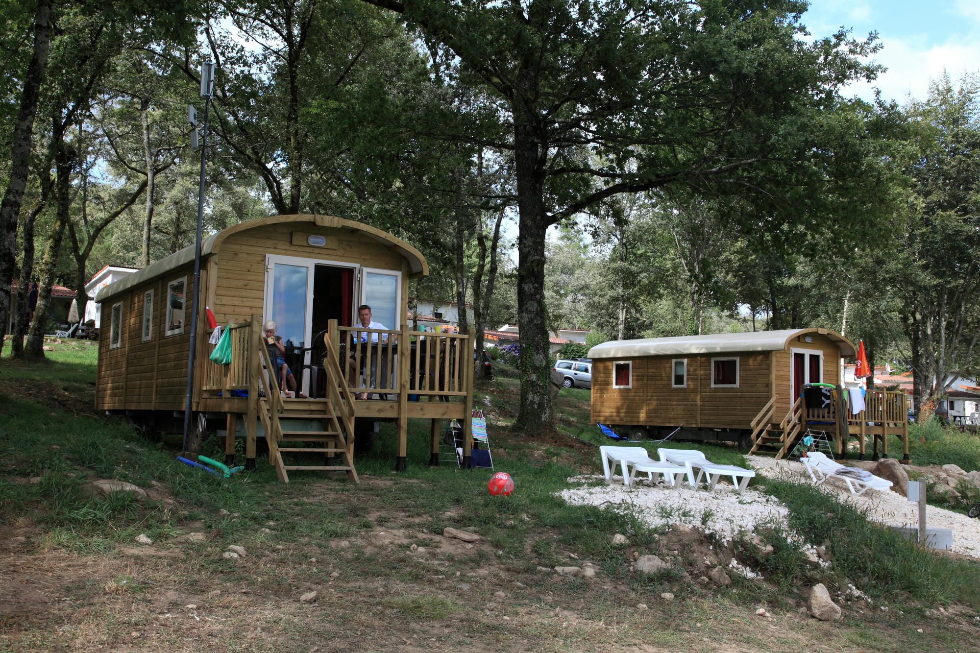 Deux roulottes en bois installées à flanc de colline, hébergements insolites au Camping Le Verdoyer