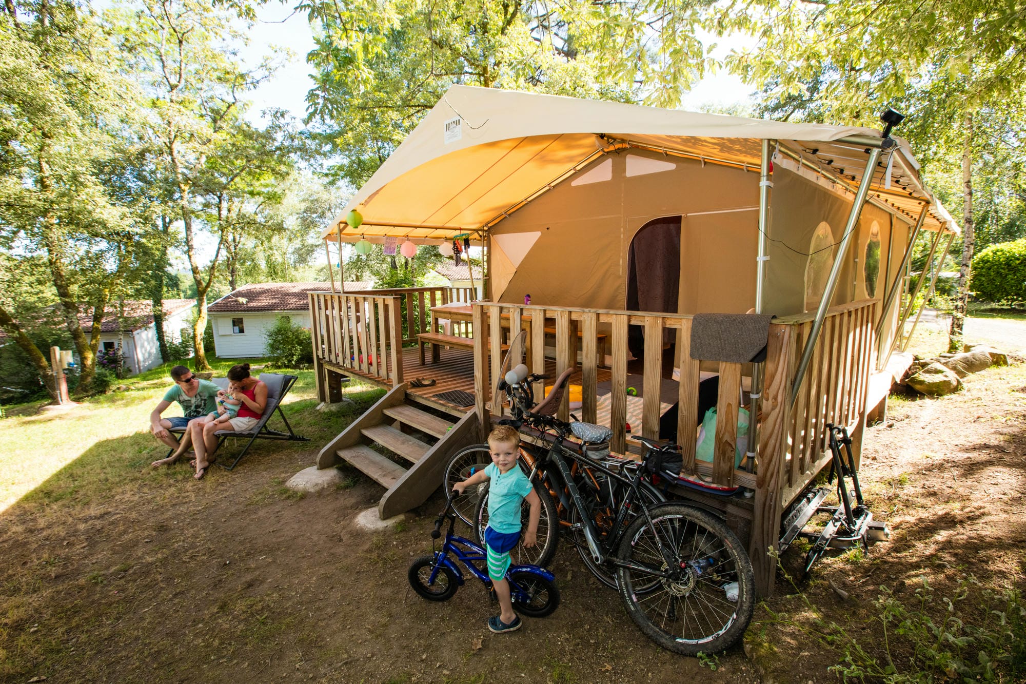 Tente lodge avec un vélo garé à côté, aventure nature au Camping Château le Verdoyer