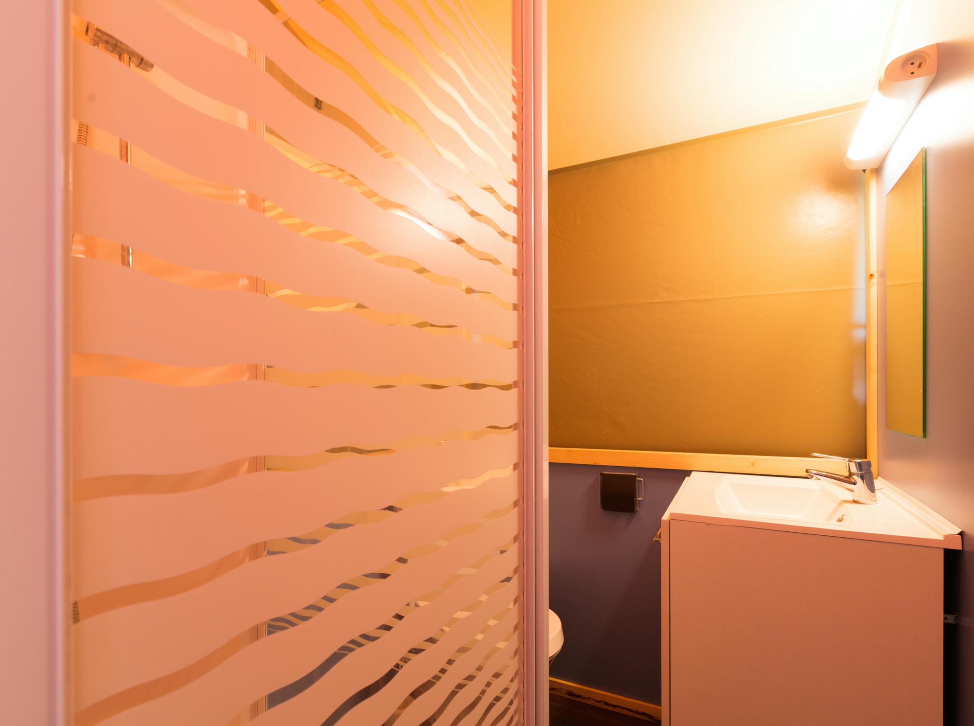 Salle d'eau avec lavabo et miroir dans une tente lodge équipée au Château le Verdoyer