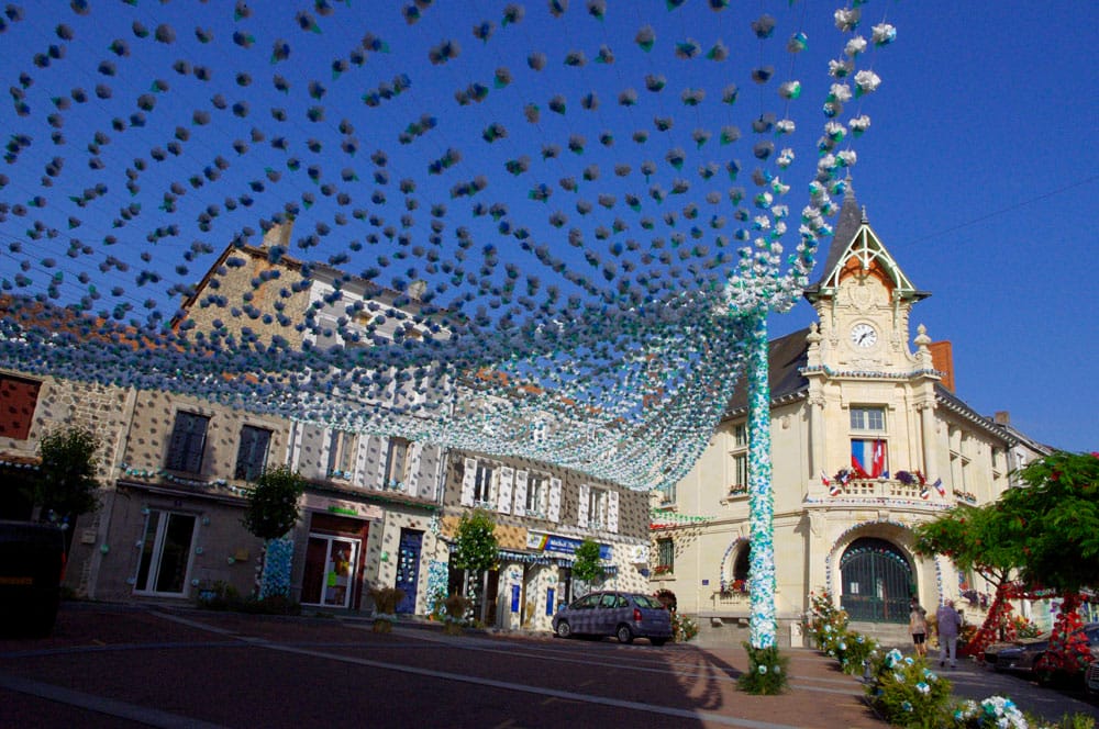 Mairie de village parée des guirlandes de la Félibrée du Périgord sous un ciel bleu, fête de la culture occitane en Dordogne