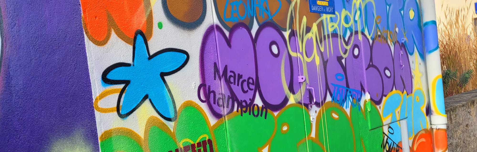 Mur tagué avec une borne d'incendie devant à Nontron, art urbain en Périgord