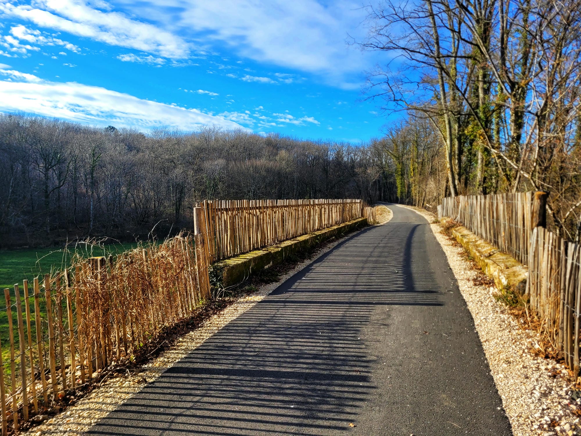 Longue route avec une clôture latérale, paysage de la Flow Vélo en Dordogne