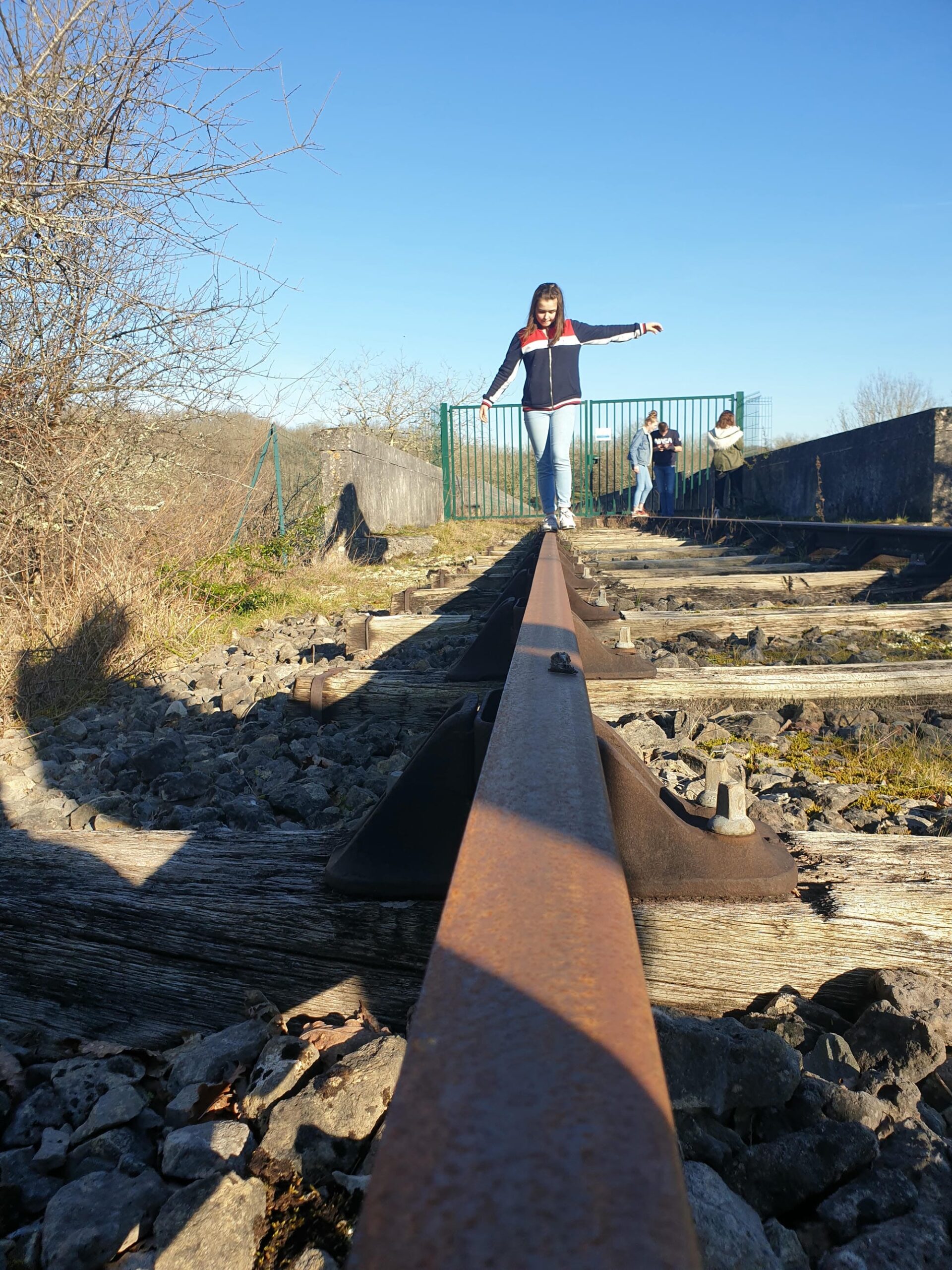 Femme en équilibre sur un rail de chemin de fer désaffecté, paysage du Parc Naturel Régional Périgord-Limousin