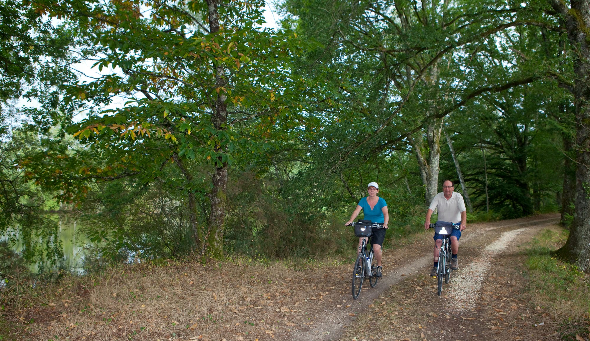 Deux cyclistes parcourant un chemin de terre en Périgord Nature, aventure à vélo