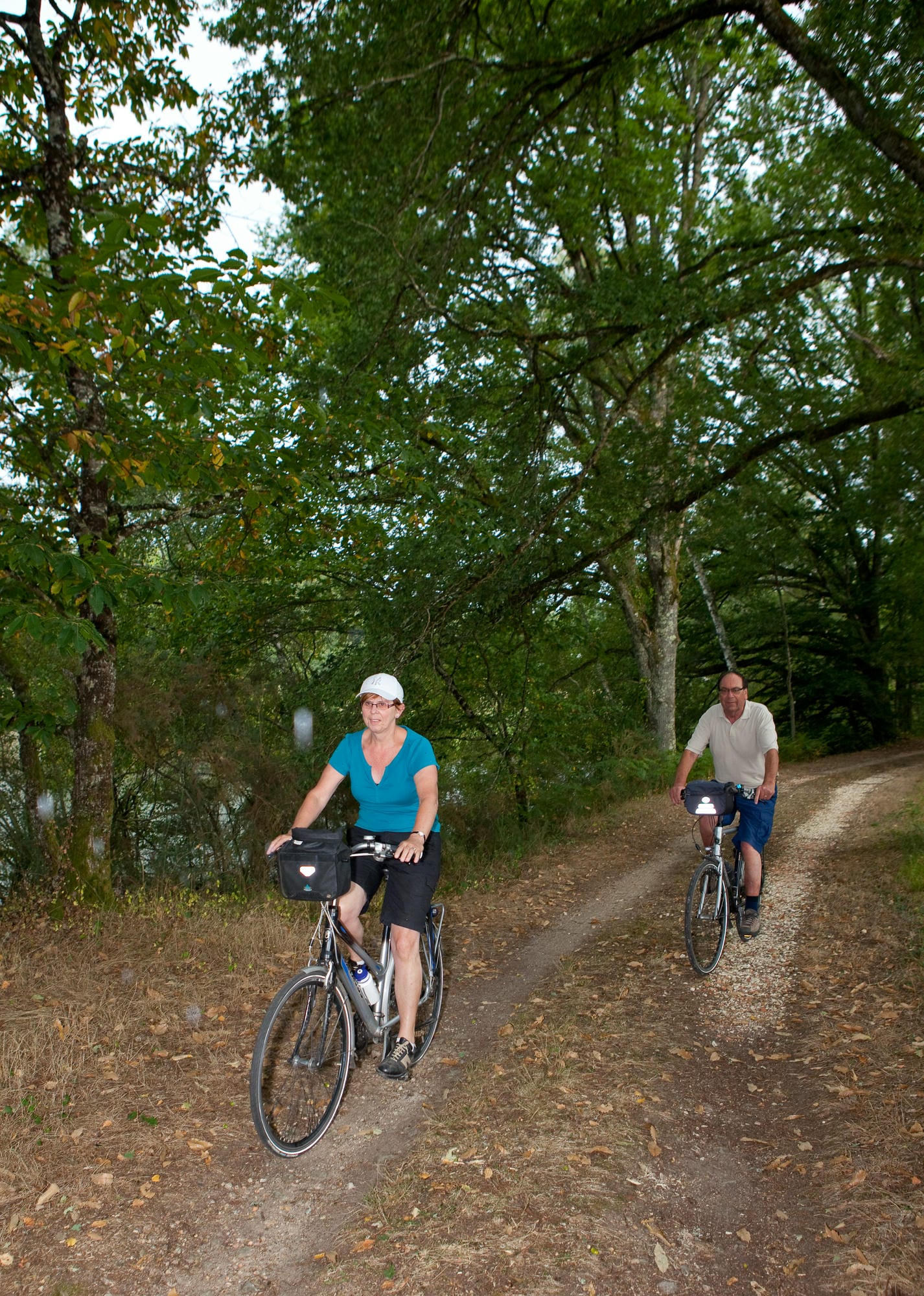 Couple de cyclistes sur un chemin de terre, randonnée VTT en Périgord Vert