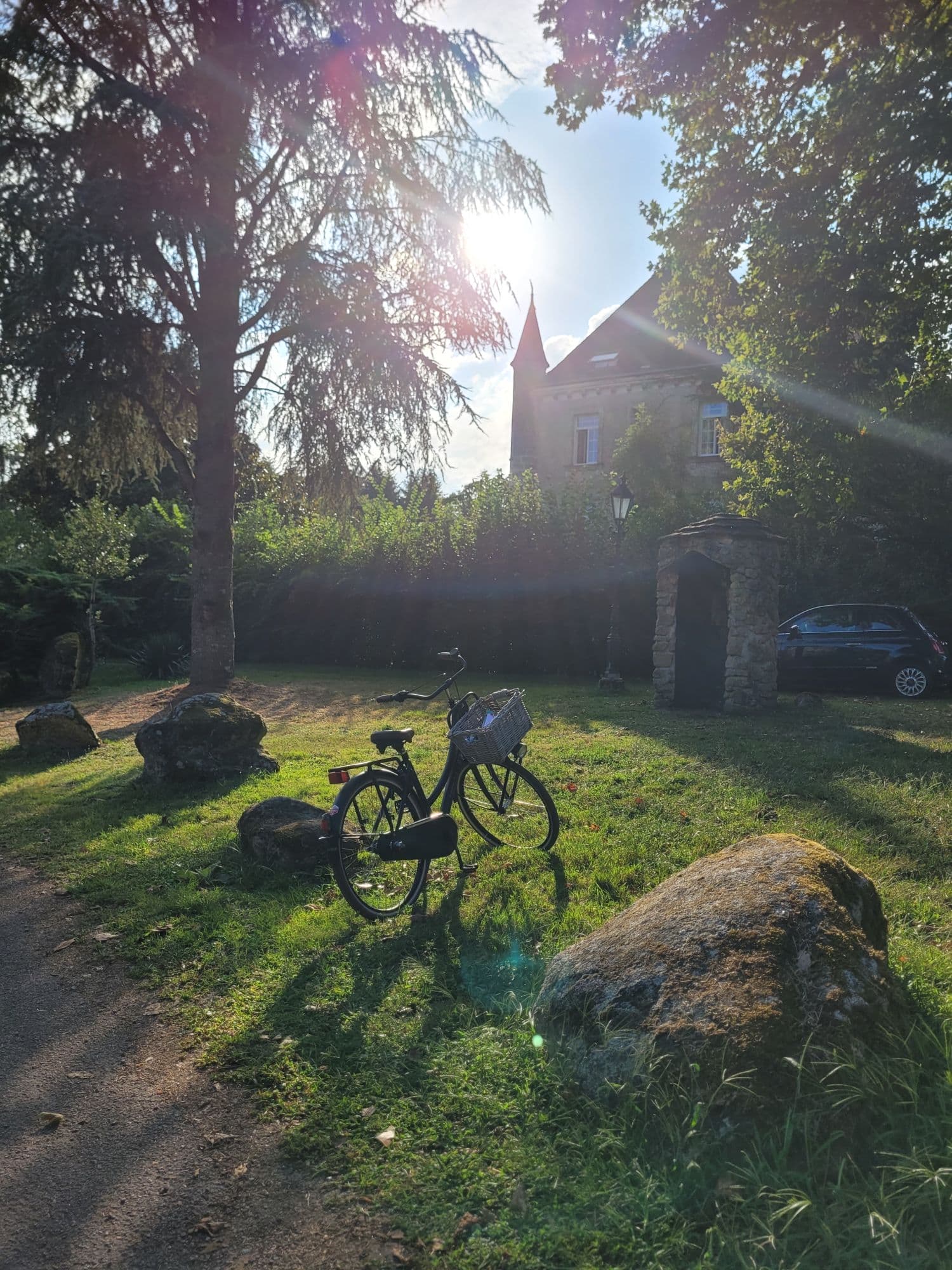 Vélo garé dans l'herbe près du château, randonnée cycliste en Périgord Nature