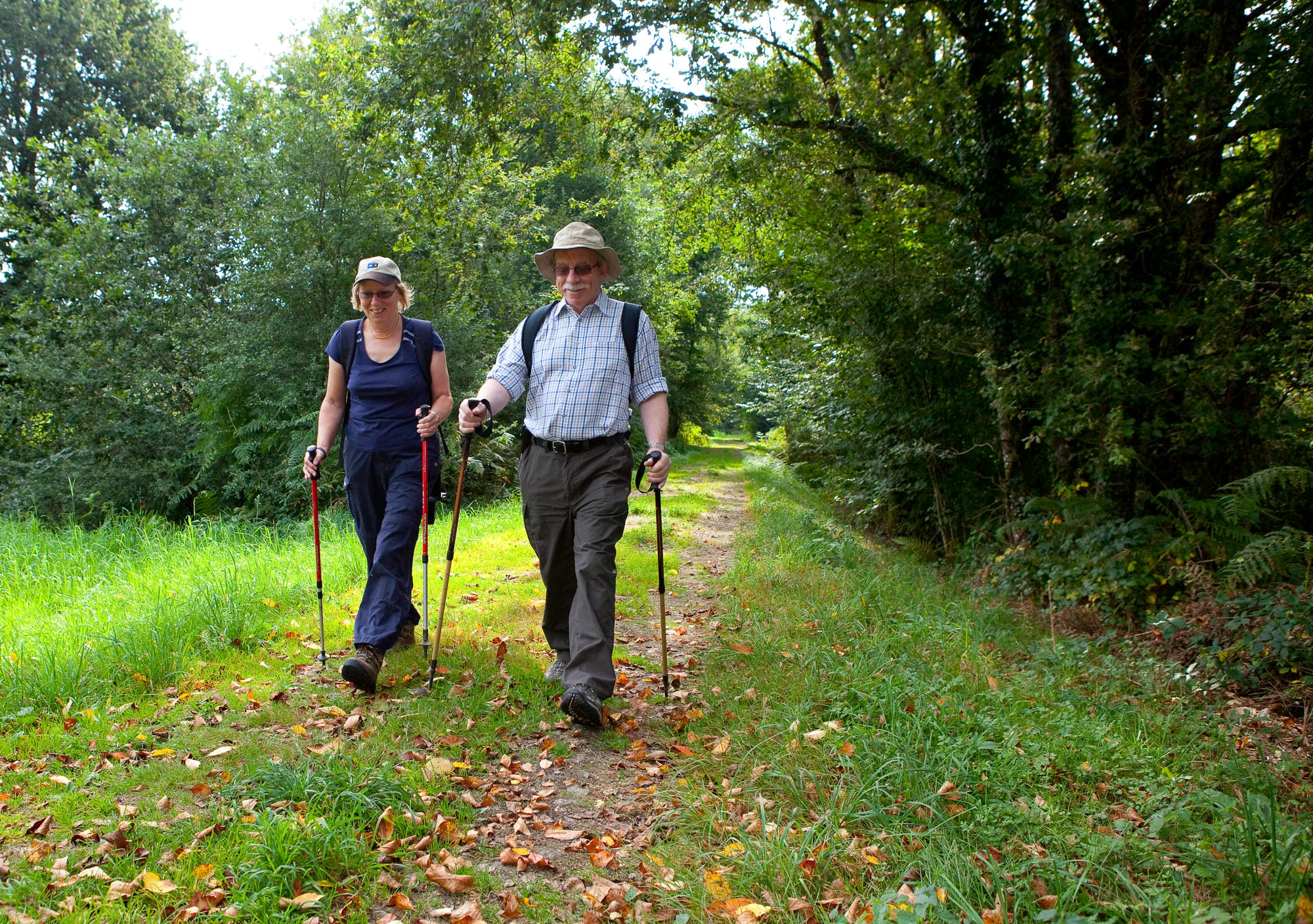 Couple en randonnée pédestre sur un sentier forestier du Périgord Vert