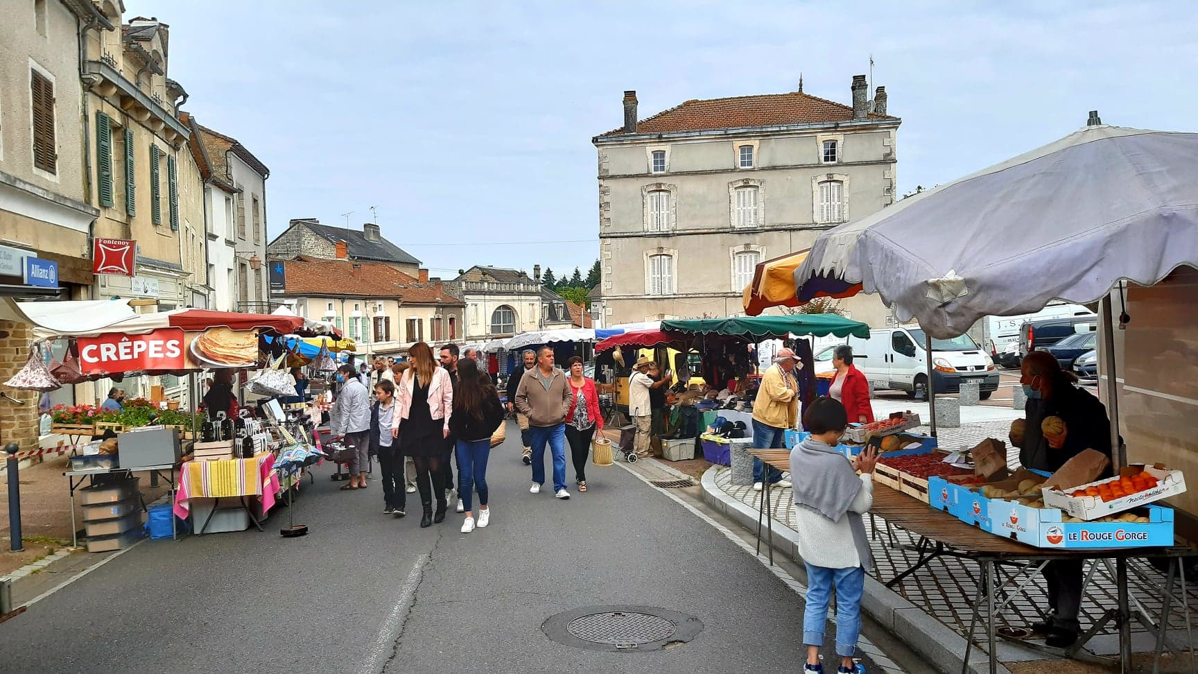 Marché animé de Piégut-Pluviers avec ses étals colorés et sa crêperie, à deux pas du camping Château le Verdoyer en Périgord Vert