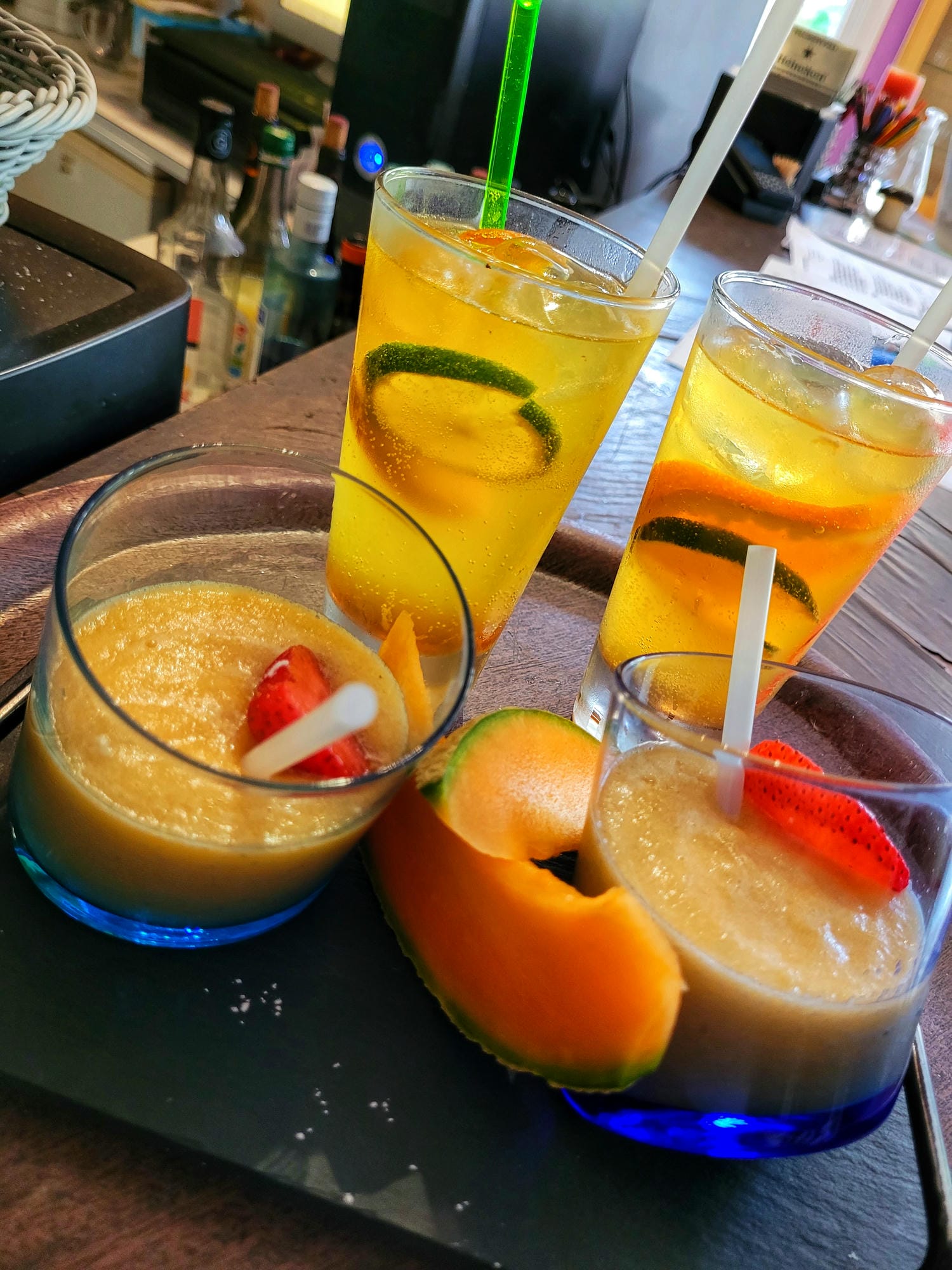 Plateau avec trois verres de cocktails colorés et fruits, bar du Camping Château le Verdoyer