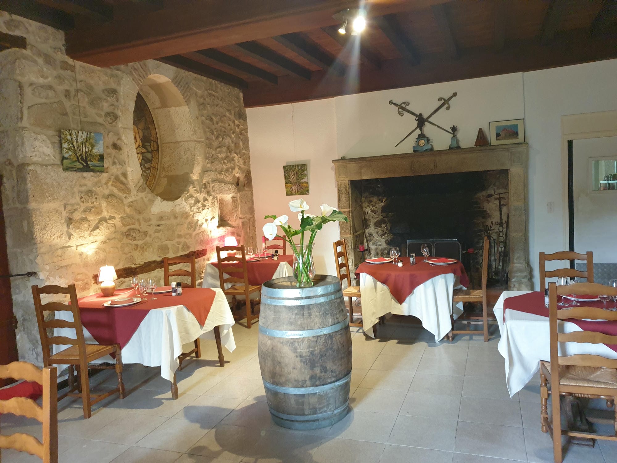 Tables et chaises dans la salle du restaurant du Château le Verdoyer, près de la cheminée